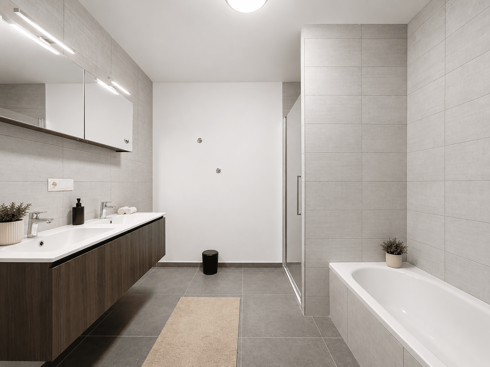 Bathroom with double basin - You Real Estate Agency Modern apartment bathroom with double washbasin, bath and glass shower.