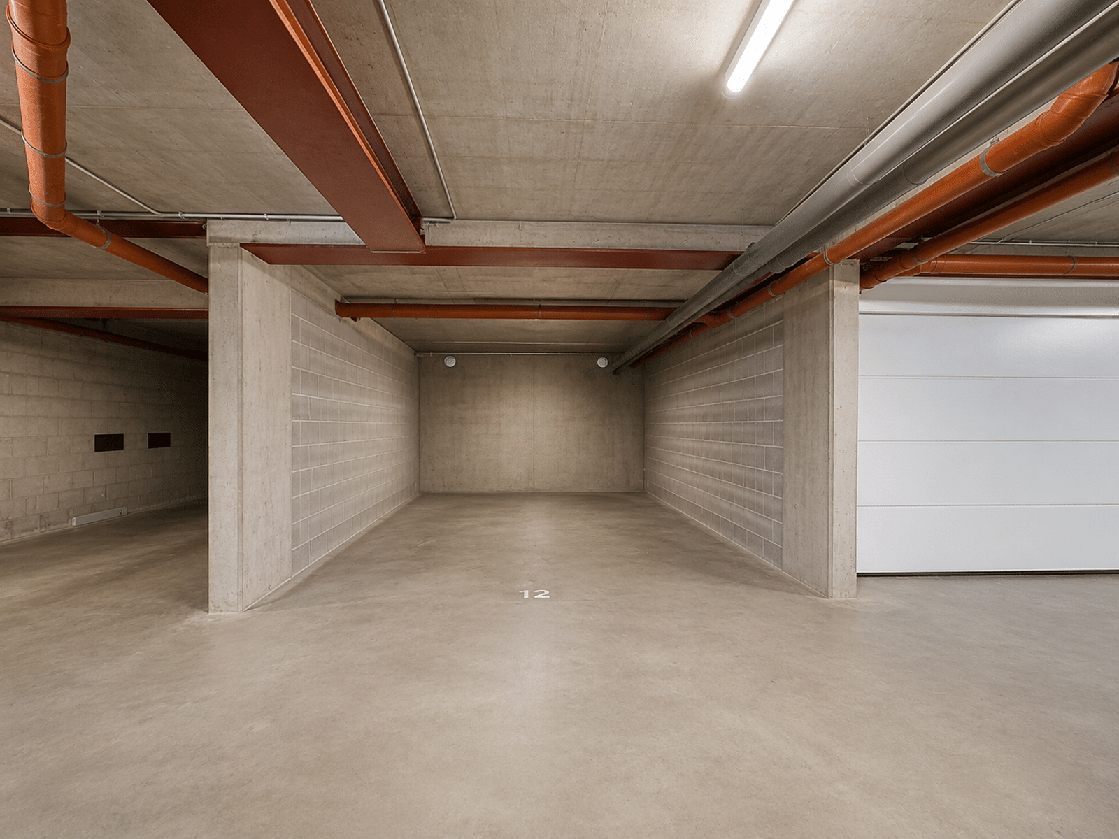 Private underground parking lot - You Real Estate Agency Private underground concrete parking space in a modern residence.
