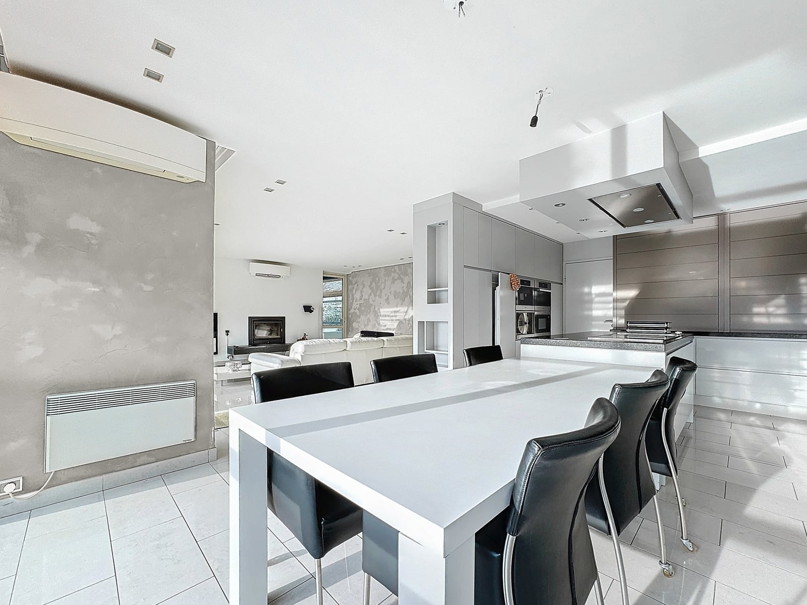 Espace de Vie Moderne Ouvert – You Real Estate Agency Maison moderne avec cuisine ouverte, salle à manger et salon lumineux.