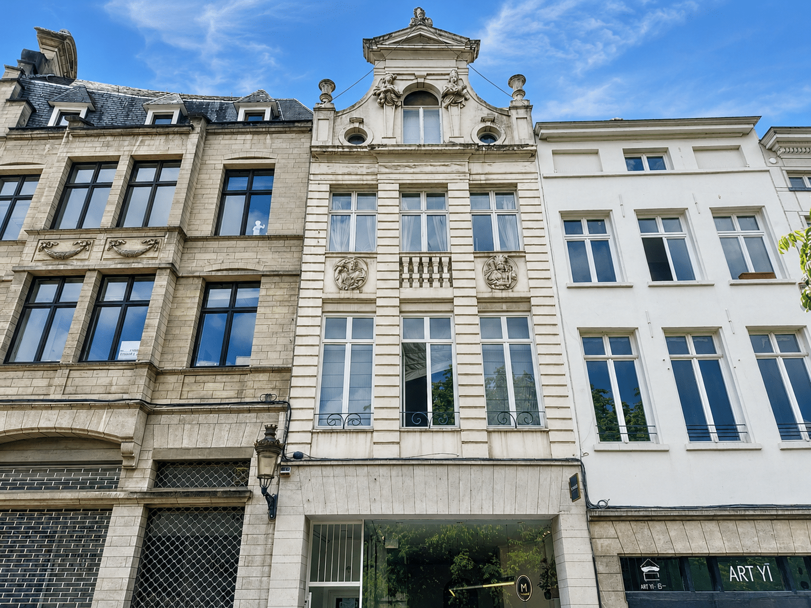 Façades Historiques en Centre-Ville – You Real Estate Agency Façades d’immeubles anciens avec appartements et commerces en centre-ville.