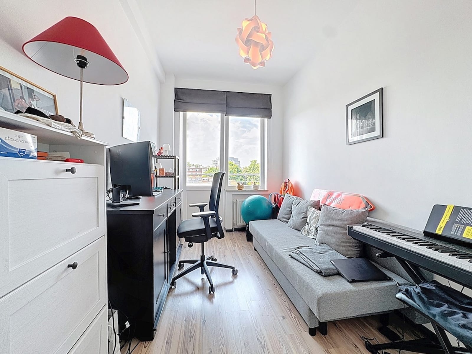 Bright Office with Gray Sofa – You Real Estate Agency A bright office with a gray sofa and a music area in a modern apartment.