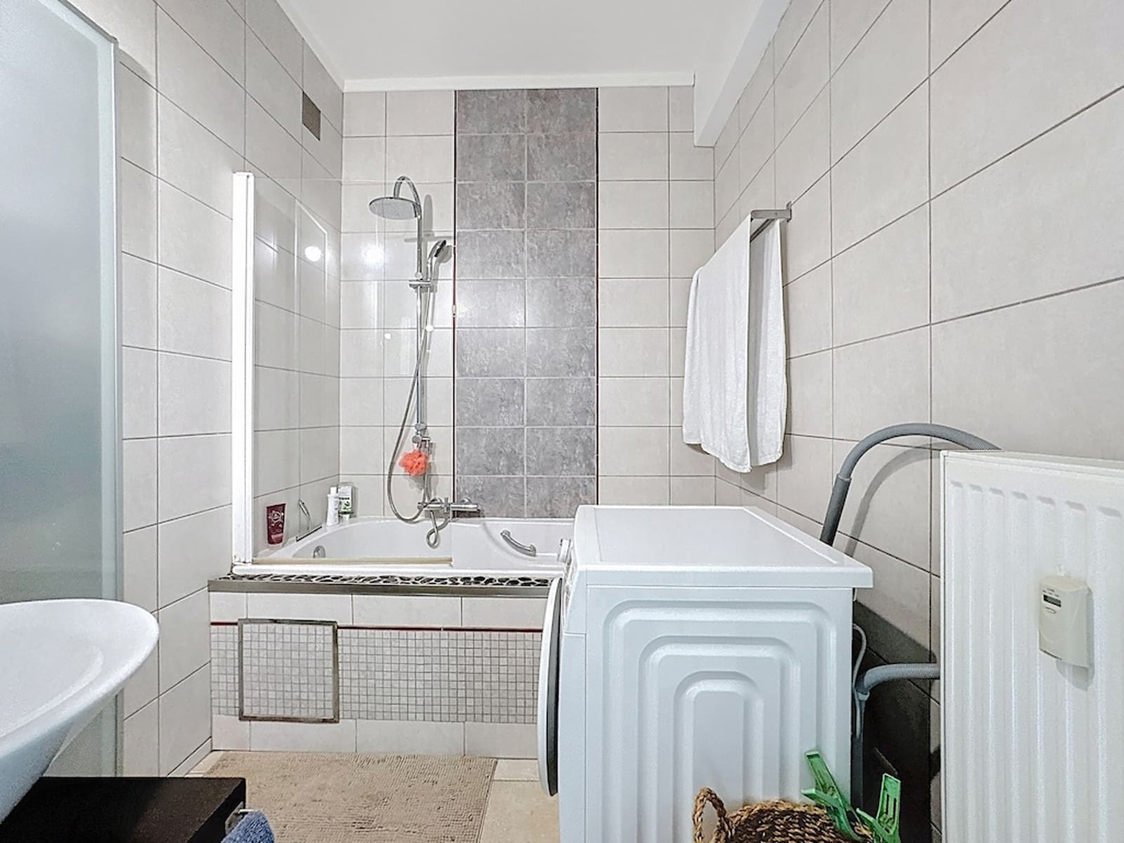 Salle de Bains Moderne - You Real Estate Agency Apartment bathroom with a bathtub, glass-enclosed shower, and washing machine.