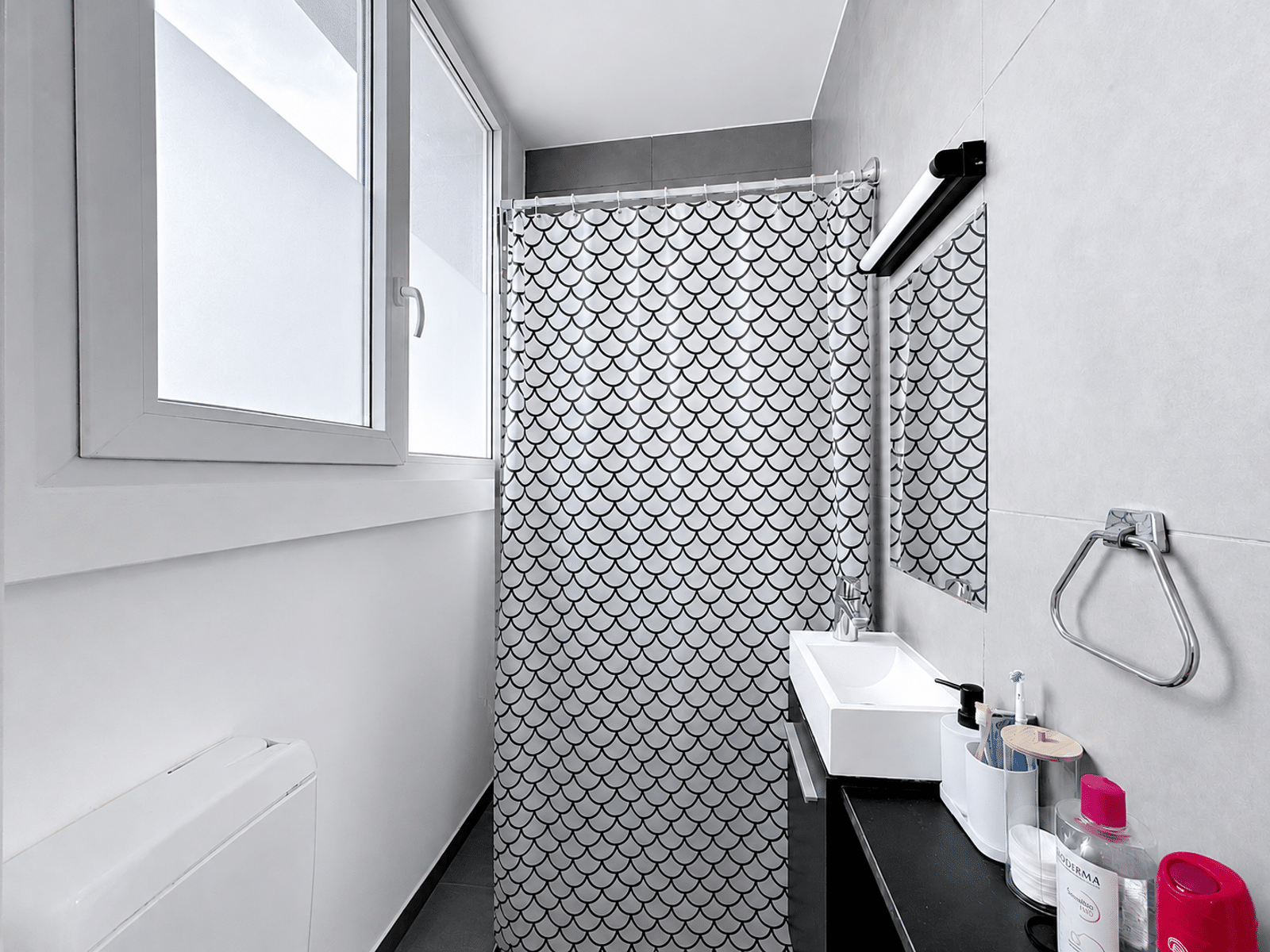 whise photo 4 Bathroom with a white window on the left, black-and-white scallop-pattern shower curtain, and a white sink.