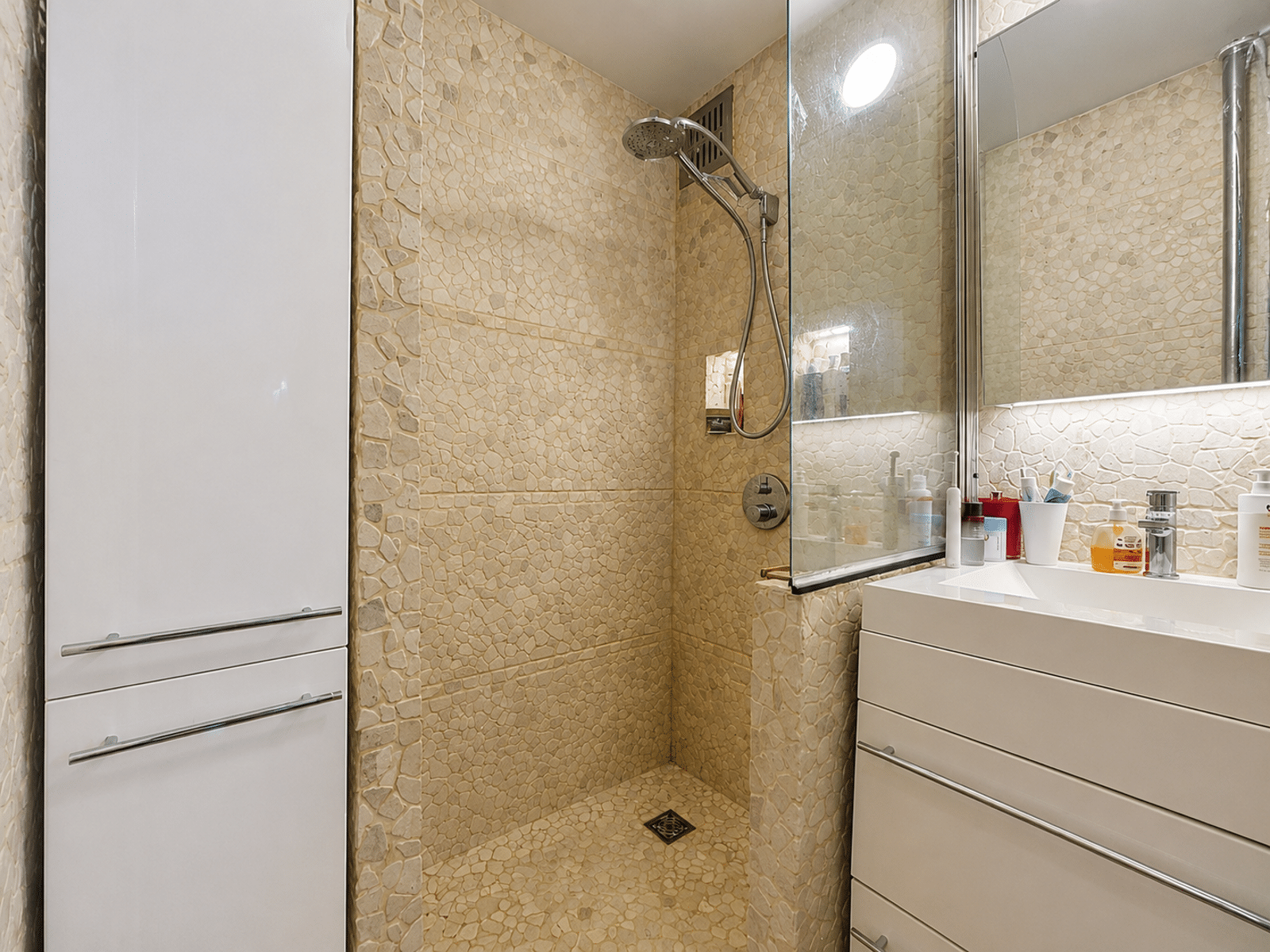 Badkamer met Italiaanse douche - U Vastgoedkantoor Moderne badkamer met inloopdouche en opbergruimte in het appartement.