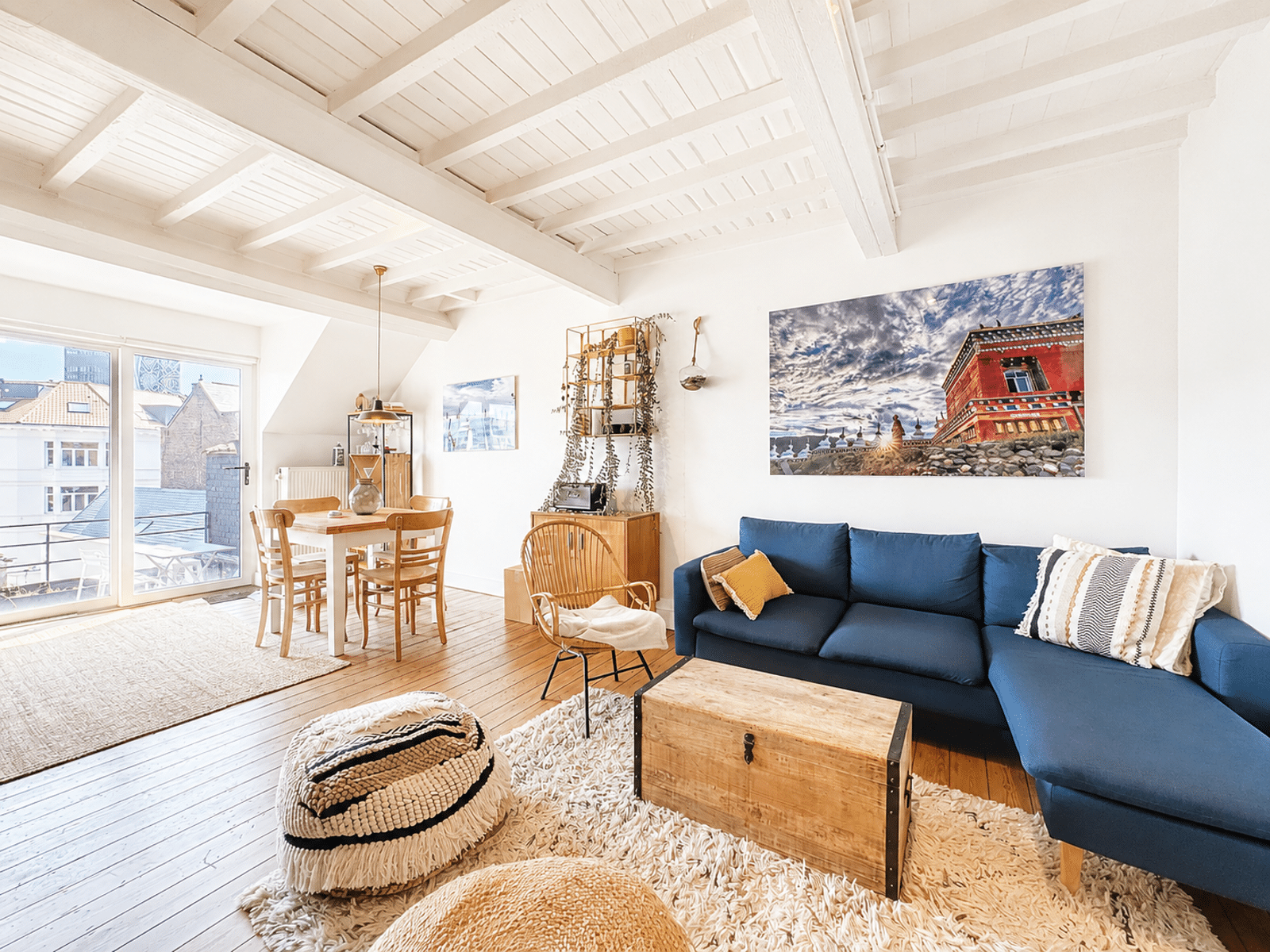 Salon Lumineux Avec Poutres Blanches – You Real Estate Agency Salon lumineux d’appartement scandinave avec poutres blanches, canapé bleu et coin repas.