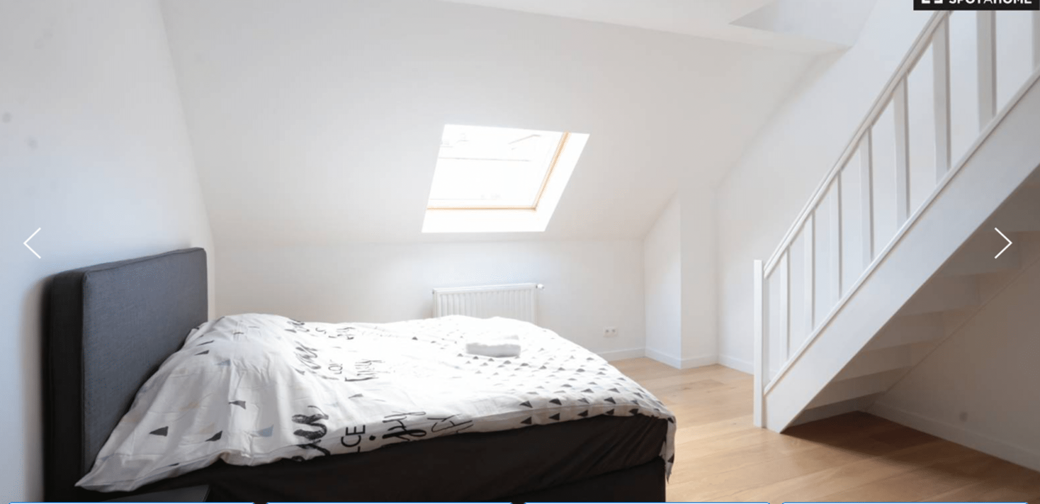 Chambre Mansardée Lumineuse avec Velux – You Real Estate Agency Chambre mansardée lumineuse avec lit, velux et escalier dans appartement moderne.