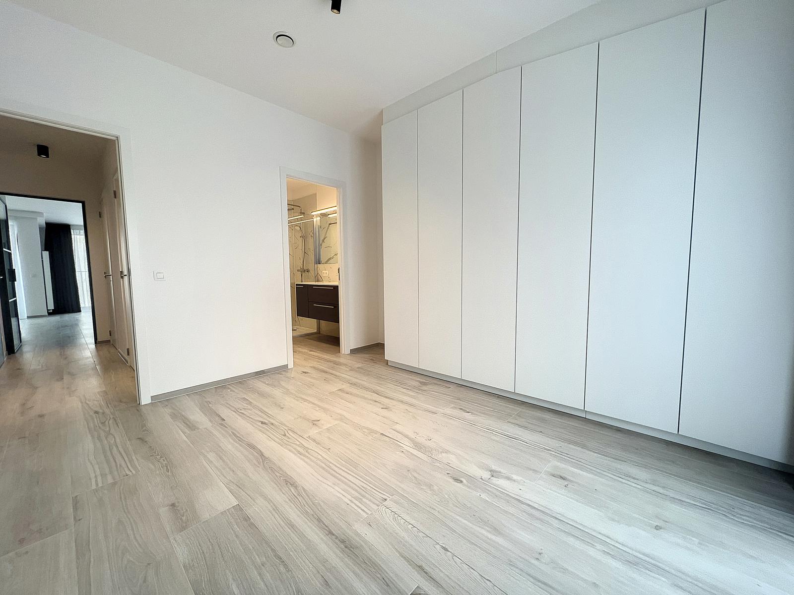 Chambre Moderne avec Placards Intégrés – You Real Estate Agency Chambre moderne avec placards intégrés et accès salle de bains dans appartement.