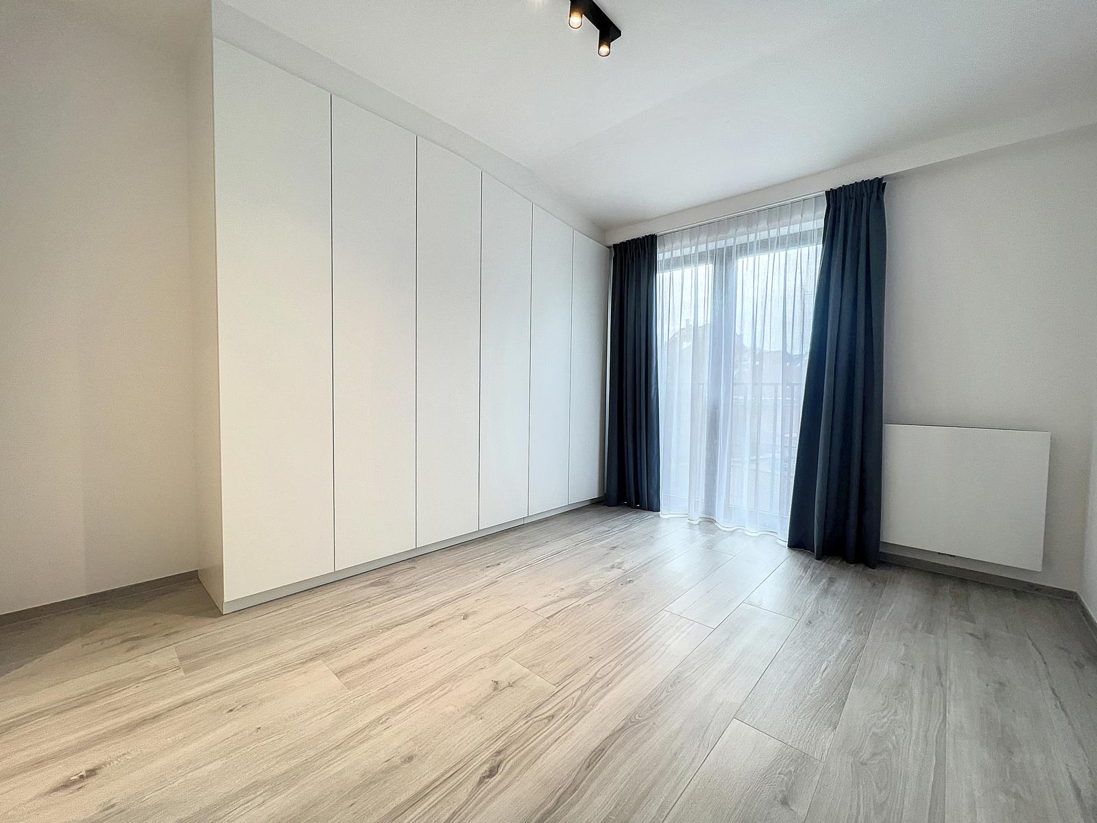 Chambre Lumineuse, Placards Intégrés – You Real Estate Agency Chambre moderne lumineuse avec placards intégrés et parquet gris dans appartement.