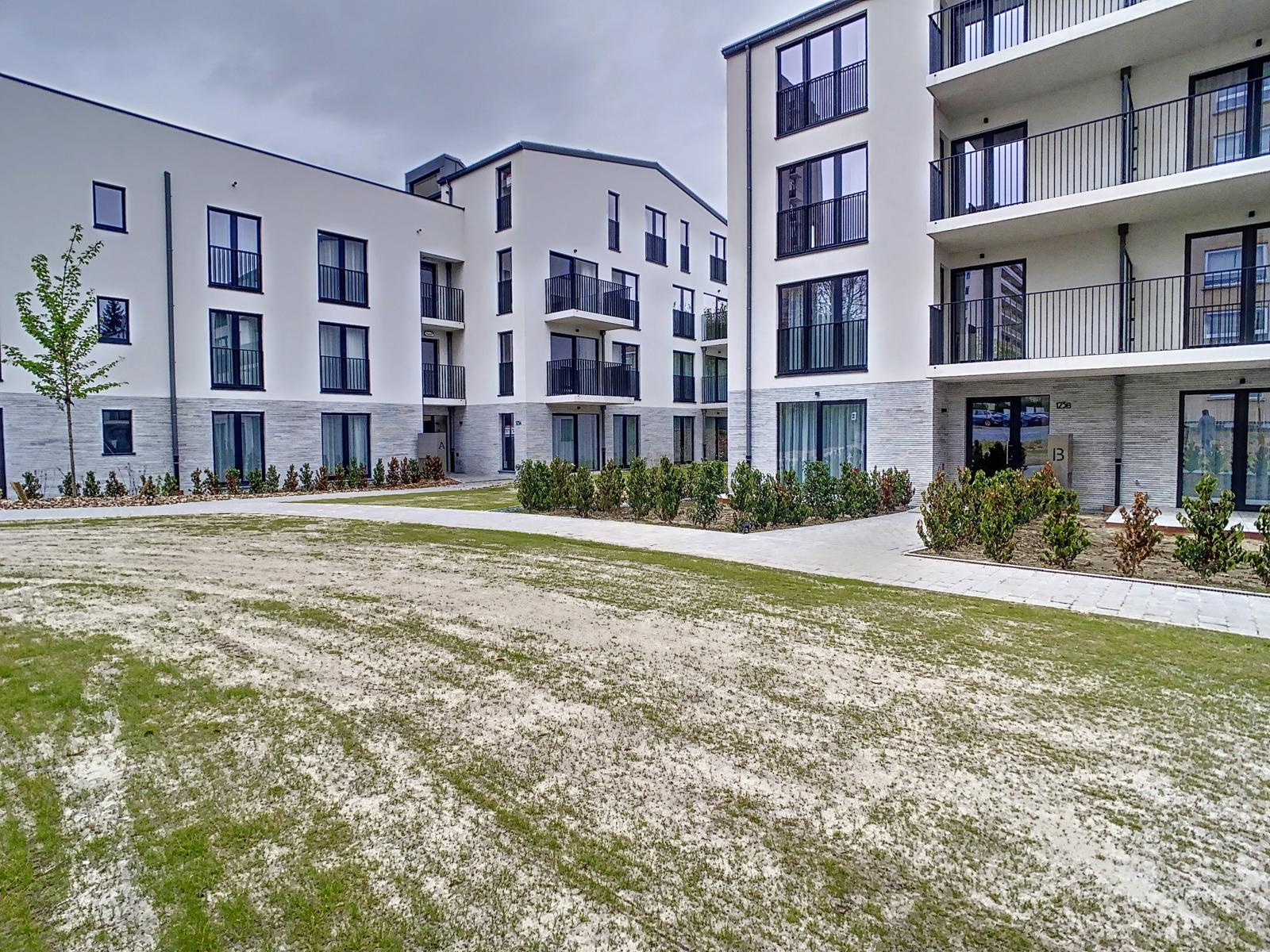Résidence Moderne avec Cour Paysagée – You Real Estate Agency Résidence moderne avec appartements, balcons et cour intérieure paysagée.