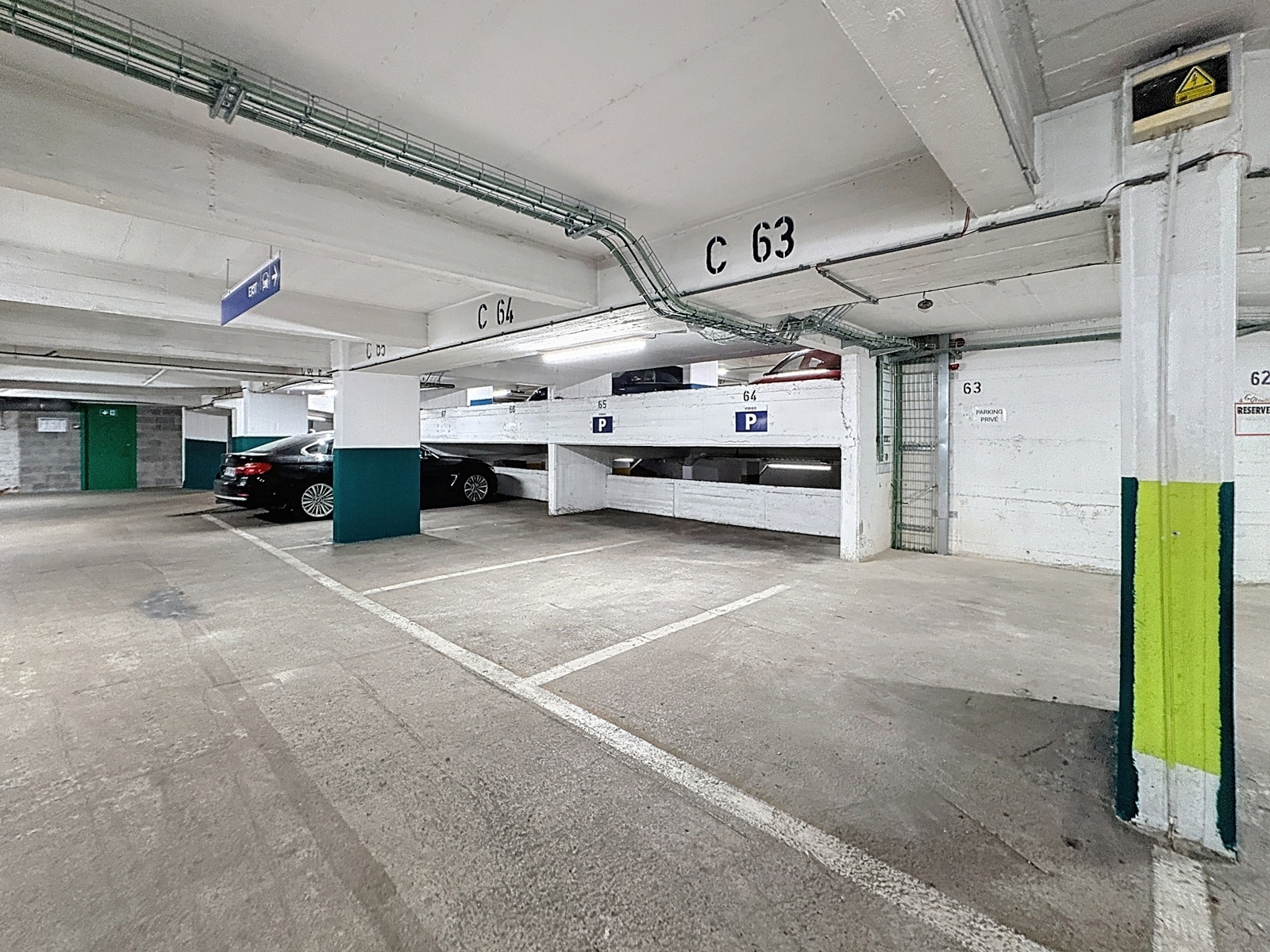 Parking Souterrain Privé Lumineux – You Real Estate Agency Parking souterrain privé lumineux avec emplacements réservés et signalétique claire.