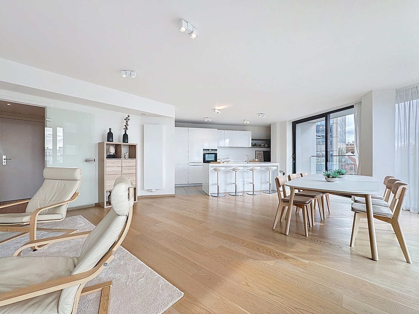 Bright living room with open kitchen - You Real Estate Agency Appartement lumineux avec salon scandinave, cuisine ouverte et salle à manger moderne.