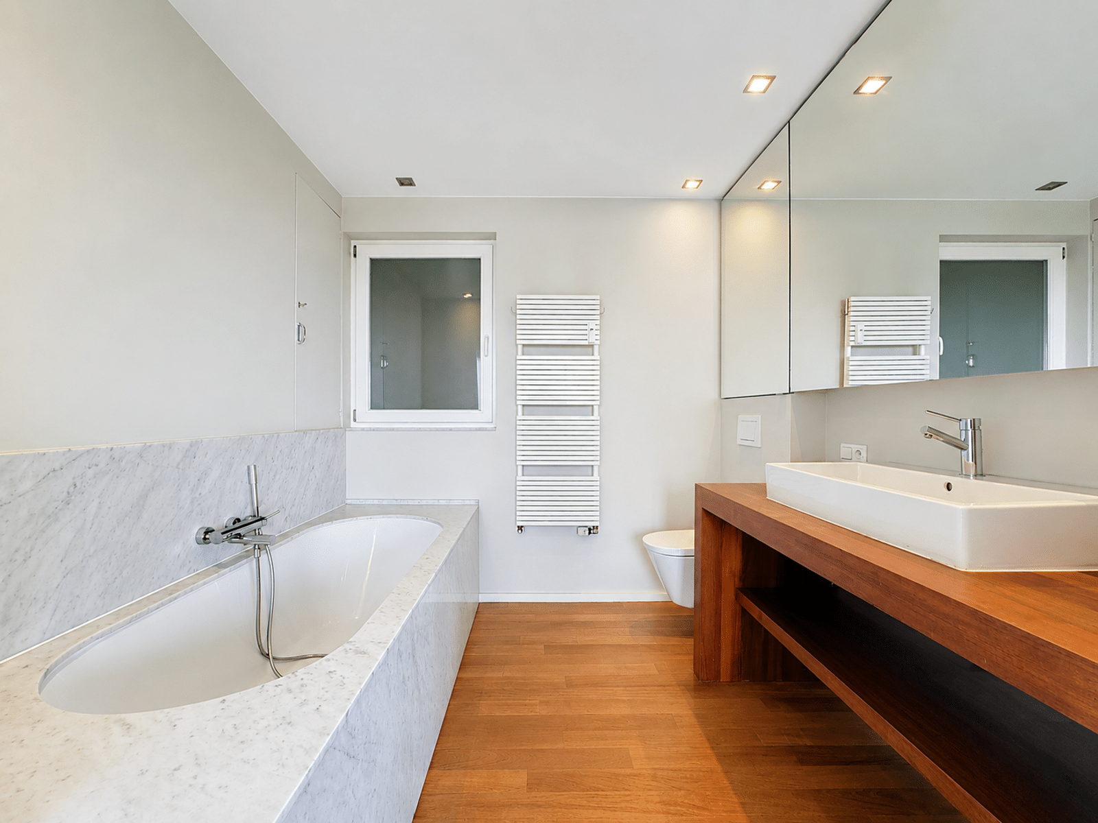 Salle de Bain Moderne avec Baignoire – You Real Estate Agency Salle de bain moderne avec baignoire, vasque et parquet dans appartement lumineux.