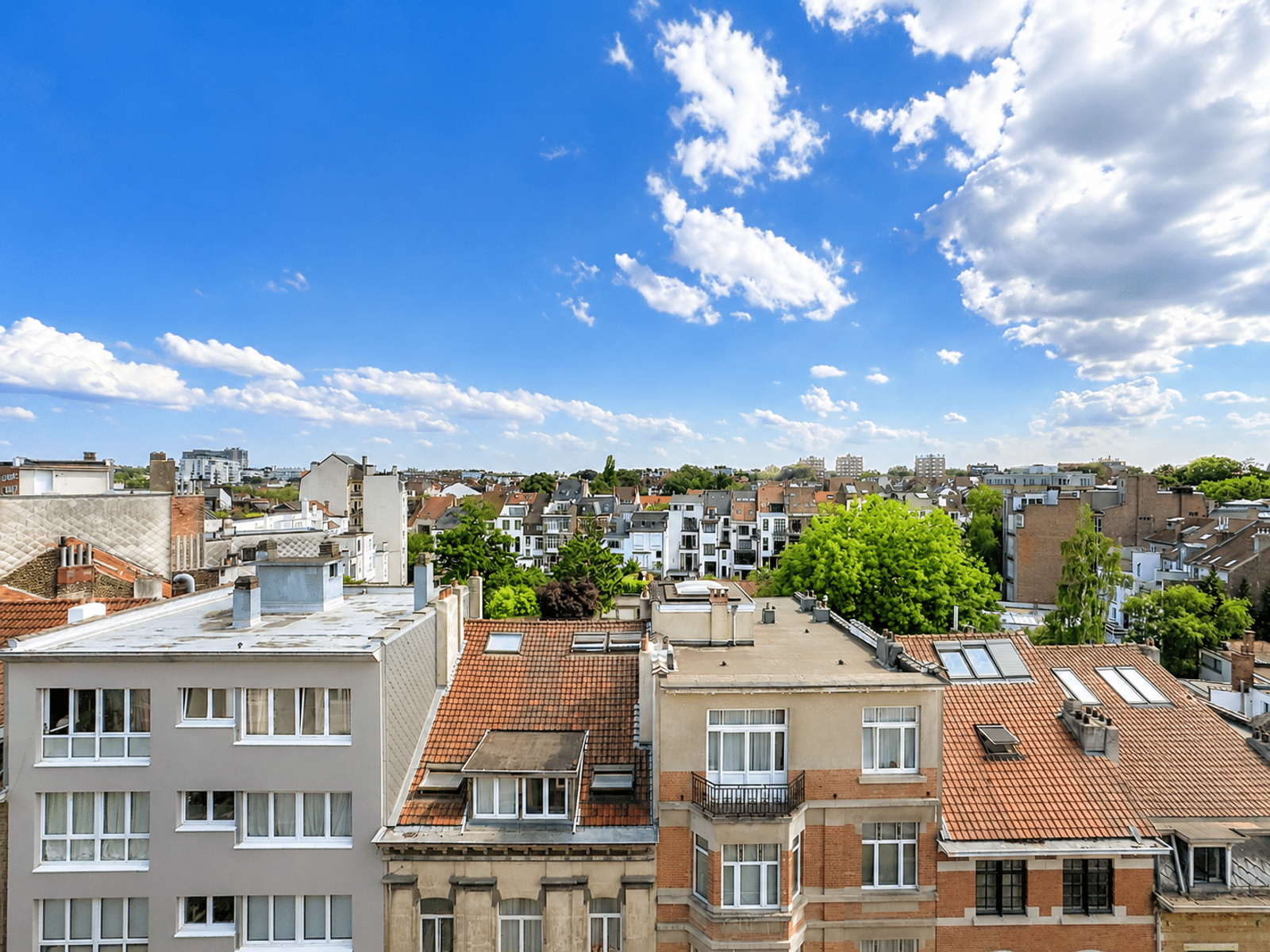 Vue Dégagée Sur Quartier Résidentiel – You Real Estate Agency Vue dégagée depuis un appartement sur quartier résidentiel et toits ensoleillés.