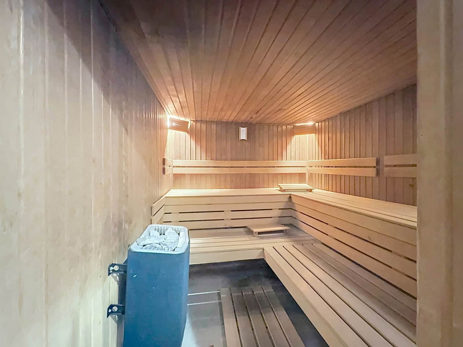 whise photo 13 Wood-paneled sauna with two-tier bench seating along the walls and warm wall lights.