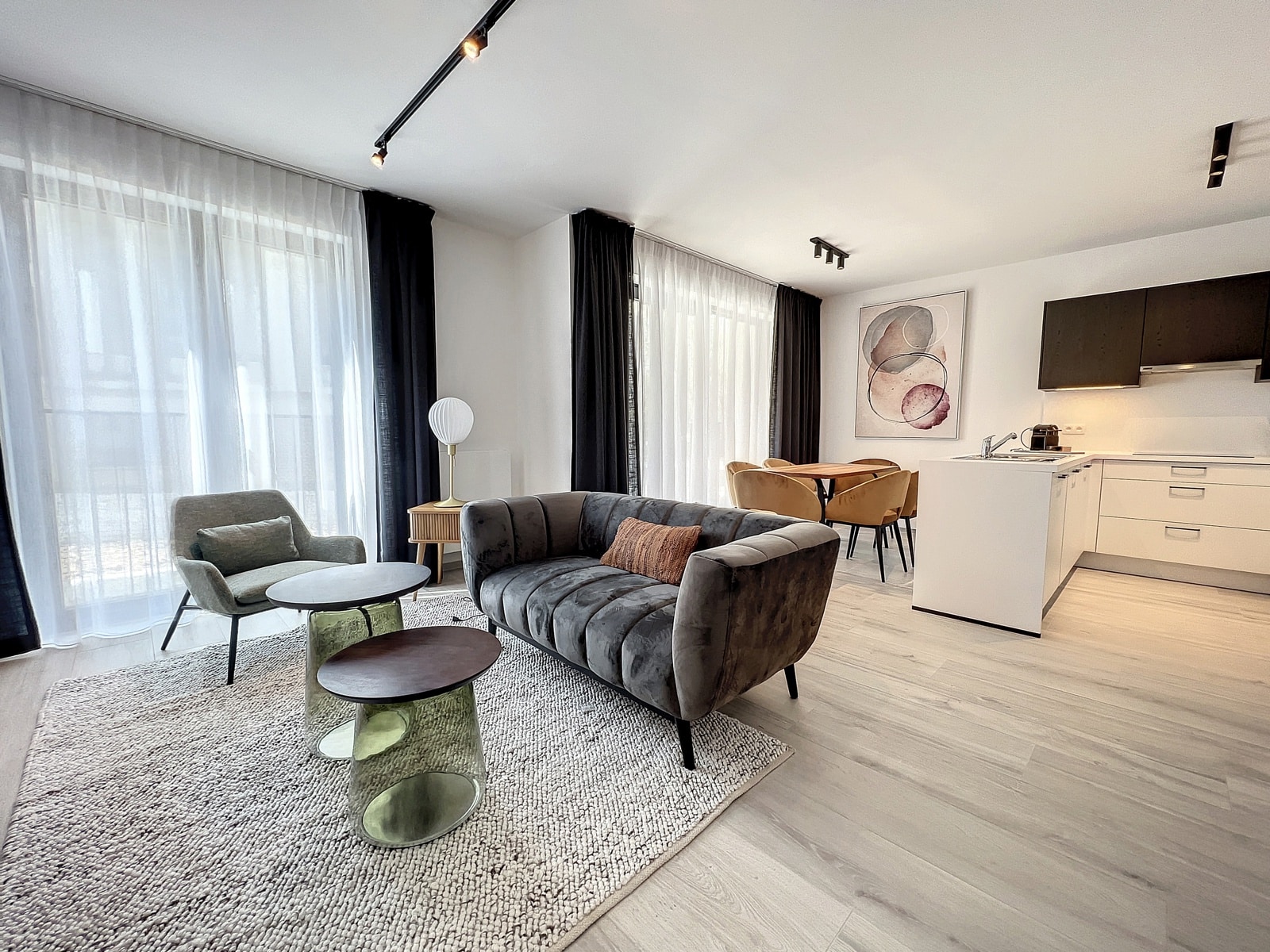 Salon Lumineux avec Cuisine Ouverte – You Real Estate Agency Appartement lumineux avec salon moderne, cuisine ouverte et espace repas contemporain.