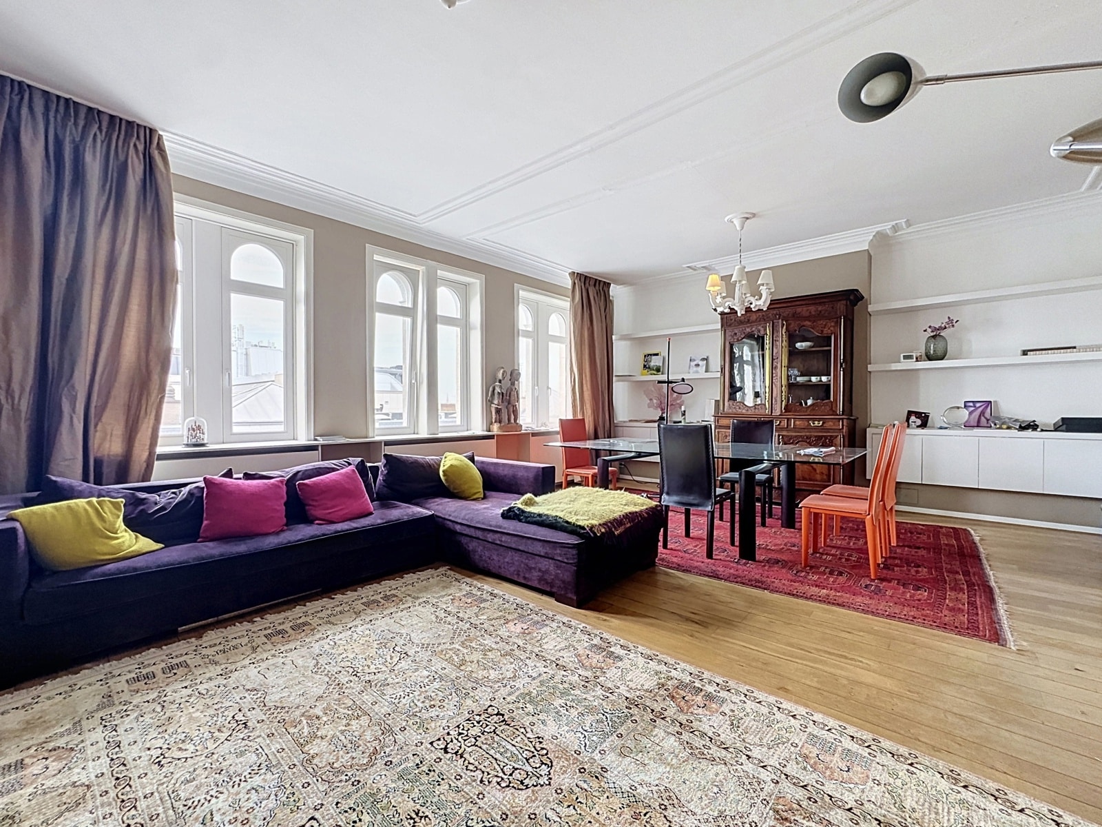 Élégant Salon-Salle à Manger Lumineux – You Real Estate Agency Appartement élégant avec salon-salle à manger, hauts plafonds, grandes fenêtres et parquet clair.