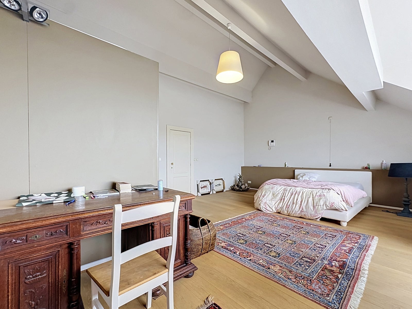 Chambre Loft avec Poutres Apparentes – You Real Estate Agency Chambre spacieuse d’appartement loft avec poutres apparentes, bureau ancien et parquet clair.