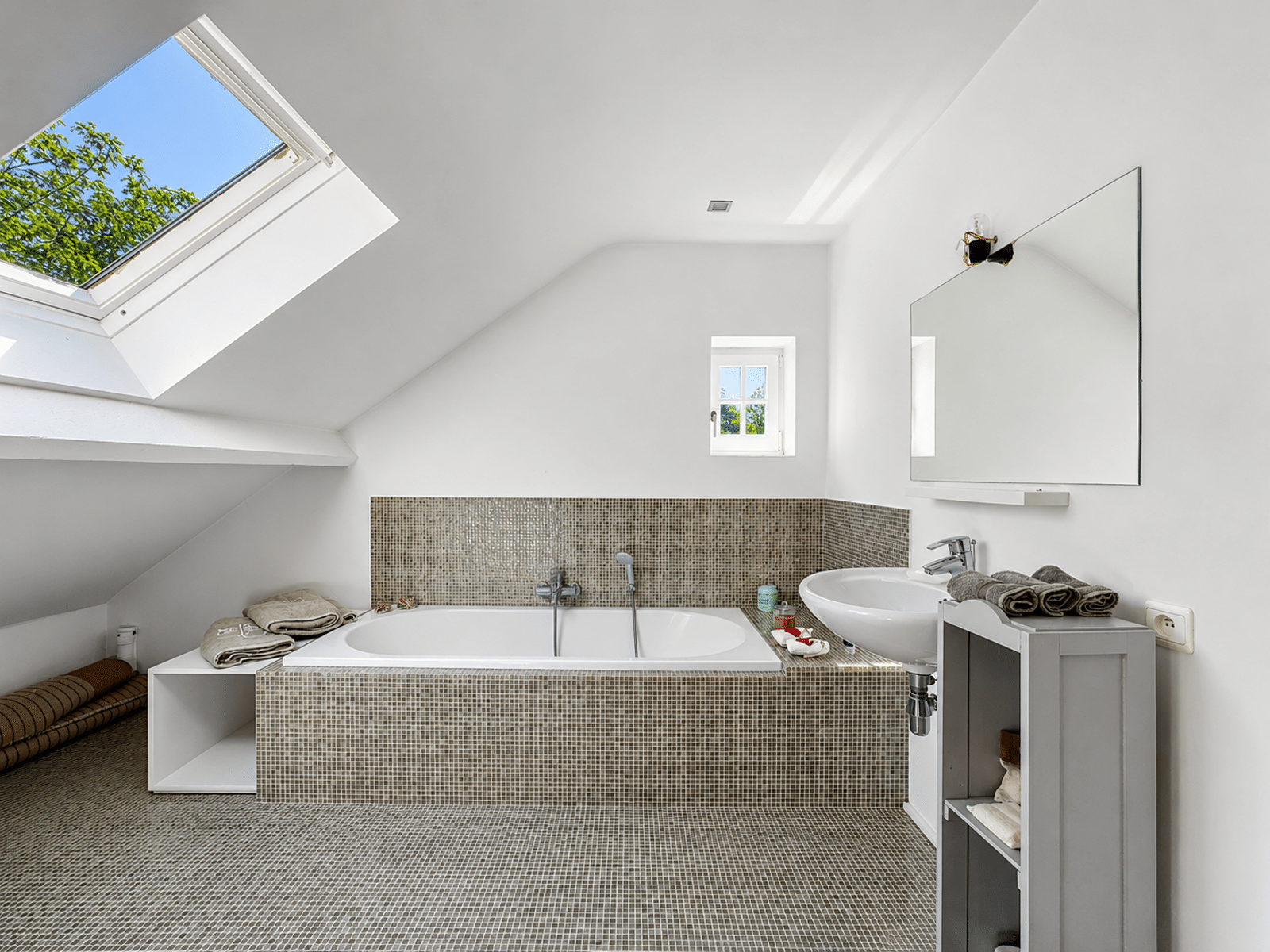 Salle de Bains Mansardée Lumineuse – You Real Estate Agency Salle de bains mansardée lumineuse avec baignoire encastrée et vélux.