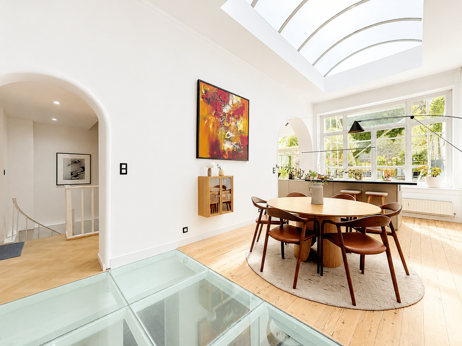 Salle à Manger Lumineuse avec Verrière – You Real Estate Agency Salle à manger lumineuse avec verrière, table ronde et vue jardin dans maison contemporaine.