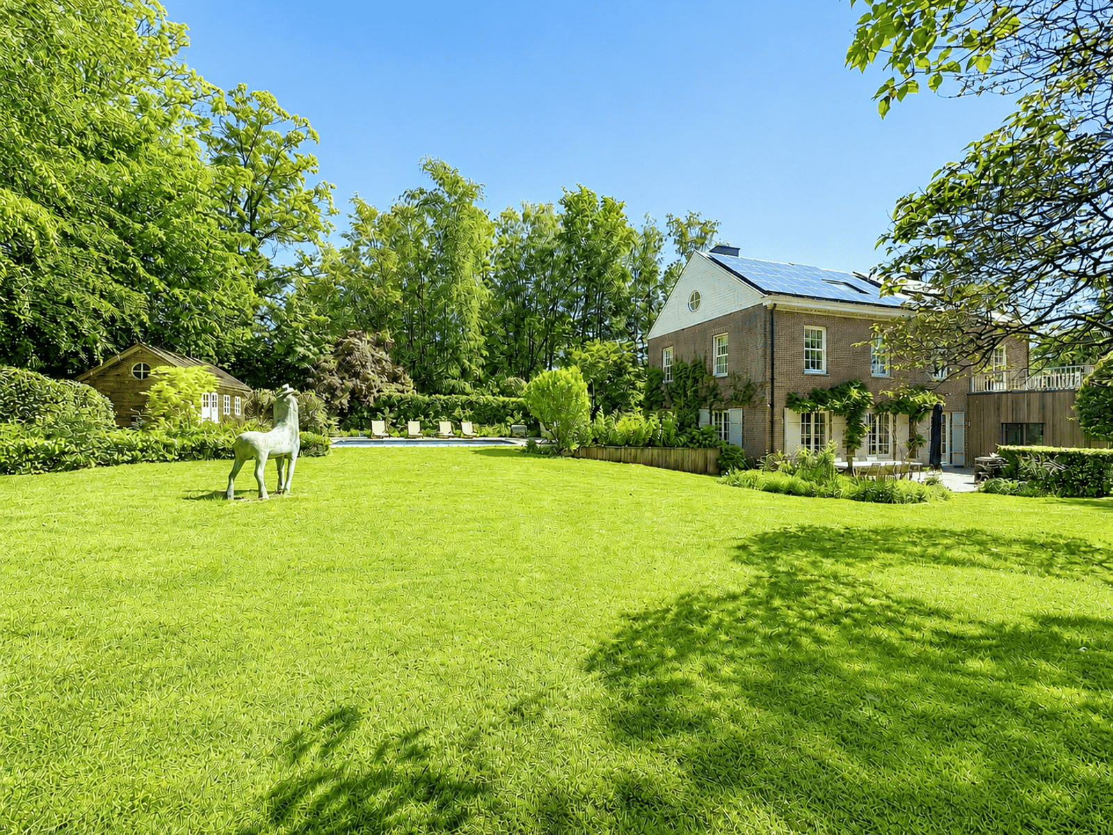 Jardin Paysager avec Piscine – You Real Estate Agency Maison de luxe avec grand jardin, terrasse, piscine et sculpture de cheval.