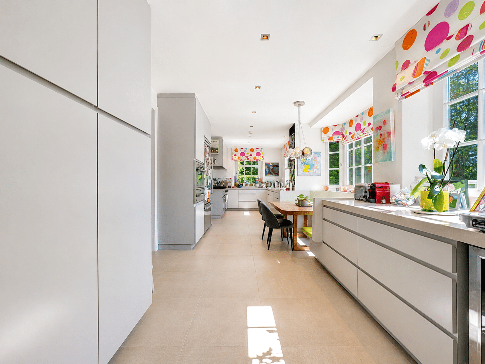 Cuisine Moderne Avec Îlot Blanc – You Real Estate Agency Cuisine moderne lumineuse avec îlot blanc, rangements intégrés et grandes fenêtres.