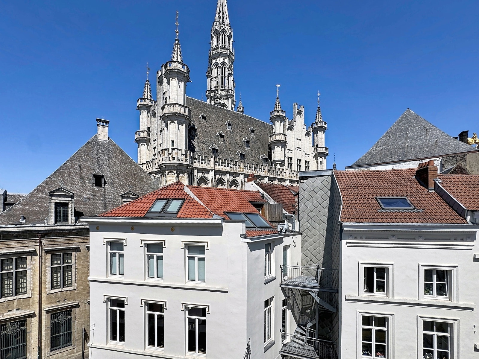 Vue sur Monument Gothique – You Real Estate Agency Appartement avec vue sur monument gothique et toits urbains en centre-ville.
