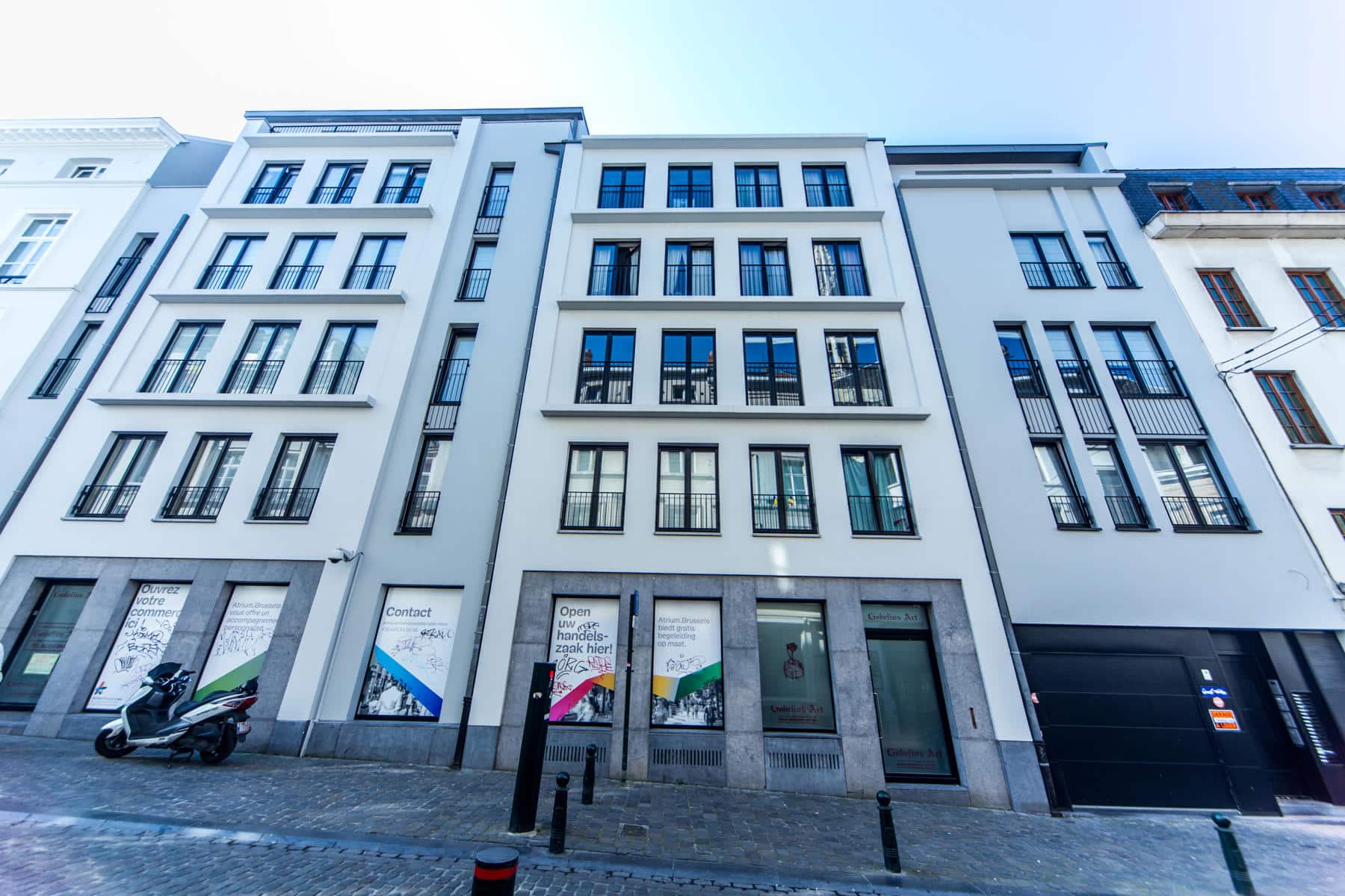 Immeuble Moderne avec Commerces – You Real Estate Agency Immeuble moderne avec appartements et commerces en rez-de-chaussée, façade rénovée en ville.