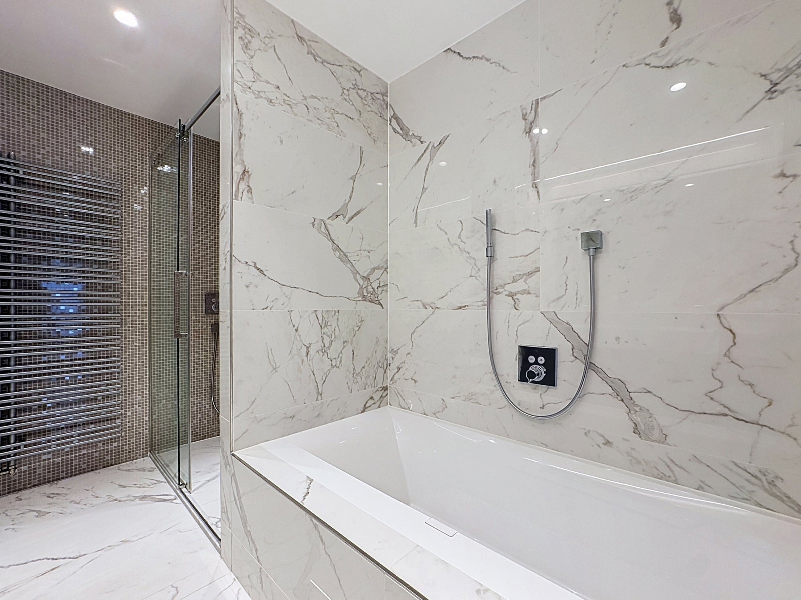 whise photo 12 Modern marble-tiled bathroom with a glass shower enclosure, a built-in bathtub, and chrome handheld shower fixtures plus a wall control panel.