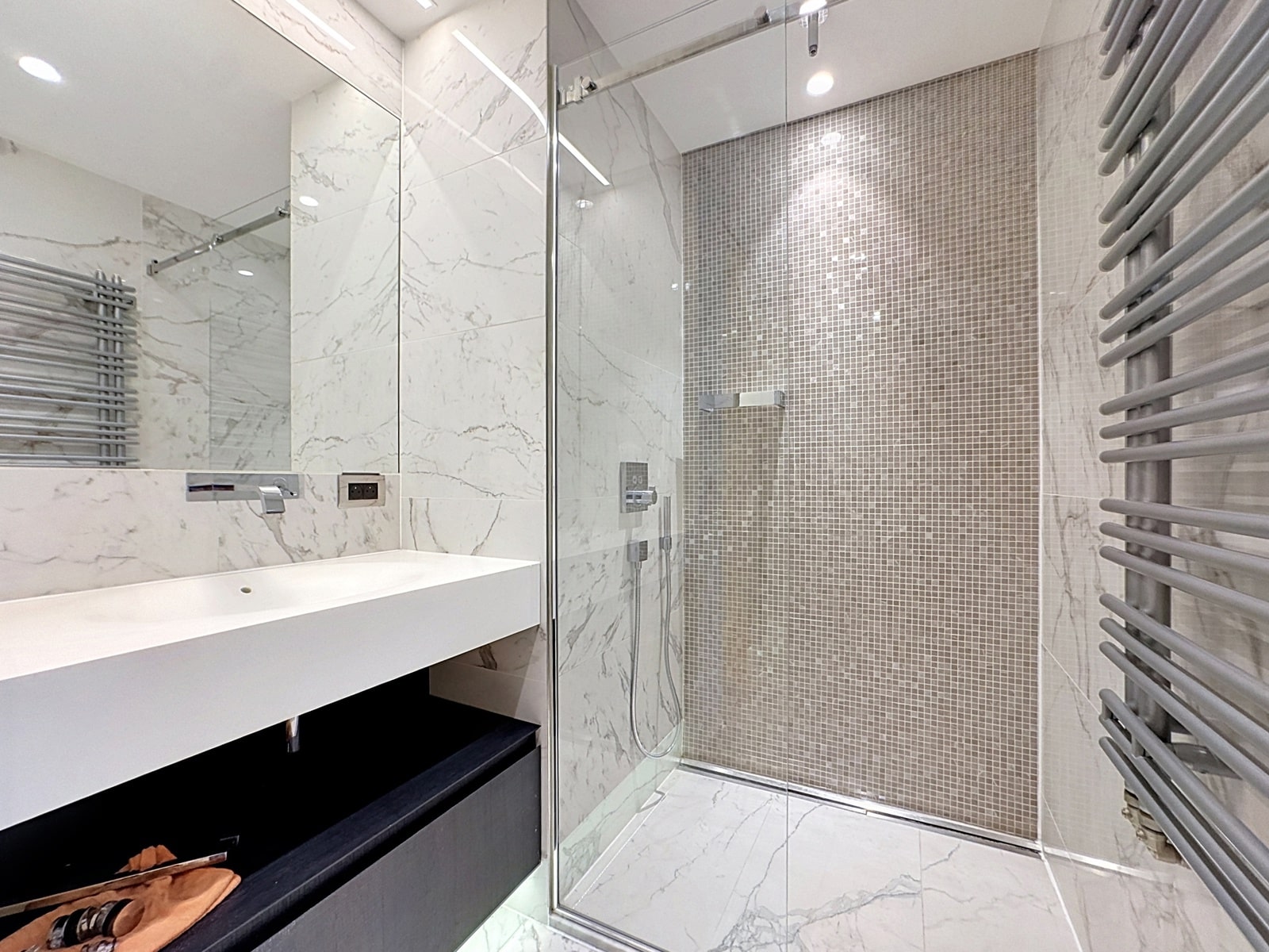 Salle de Bain avec Douche Vitrée – You Real Estate Agency Salle de bain moderne en marbre avec douche vitrée dans appartement haut de gamme.