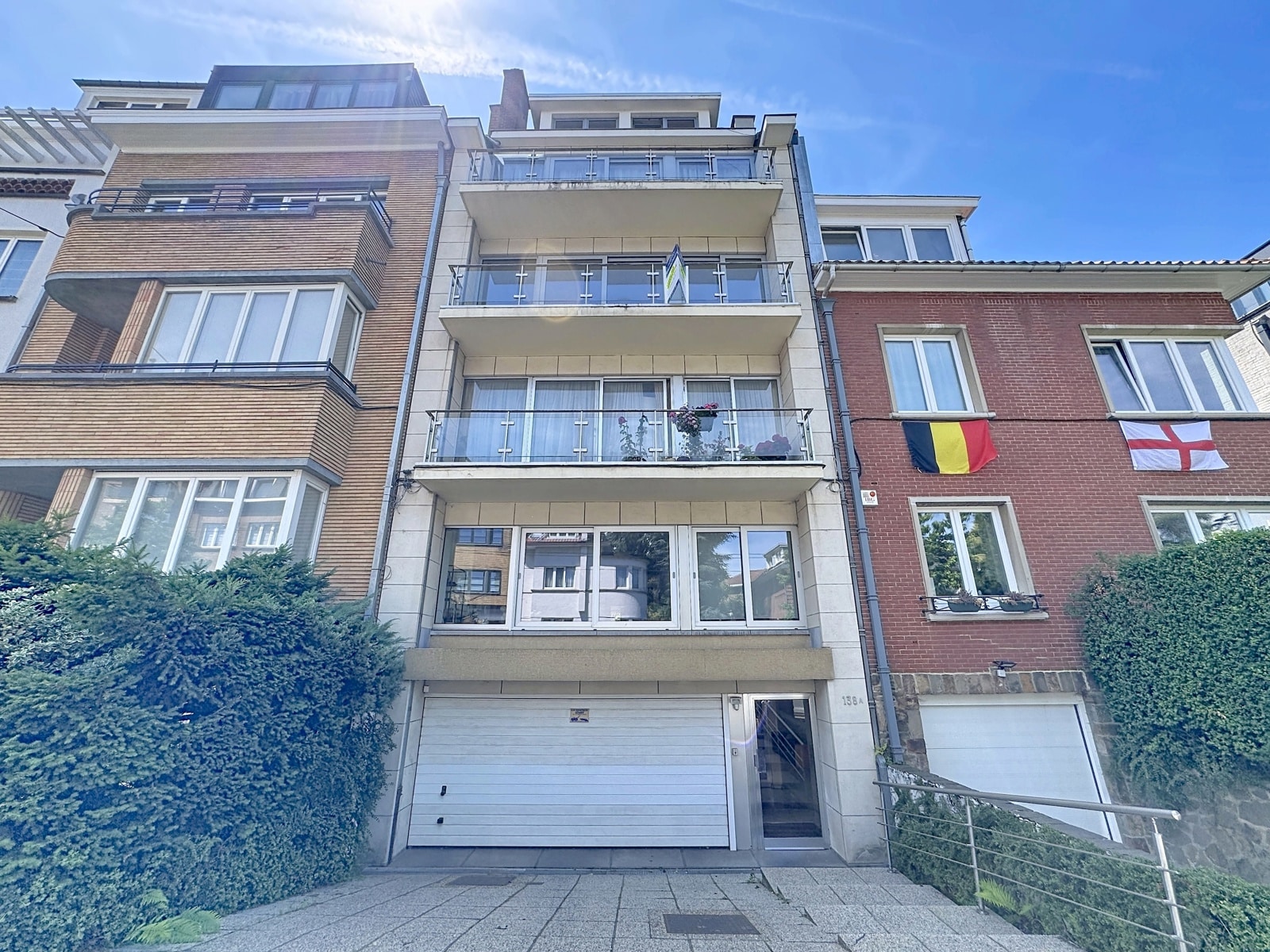 Façade d’Immeuble Moderne avec Balcons – You Real Estate Agency Immeuble résidentiel moderne avec appartements, balcons terrasses et garage en façade.