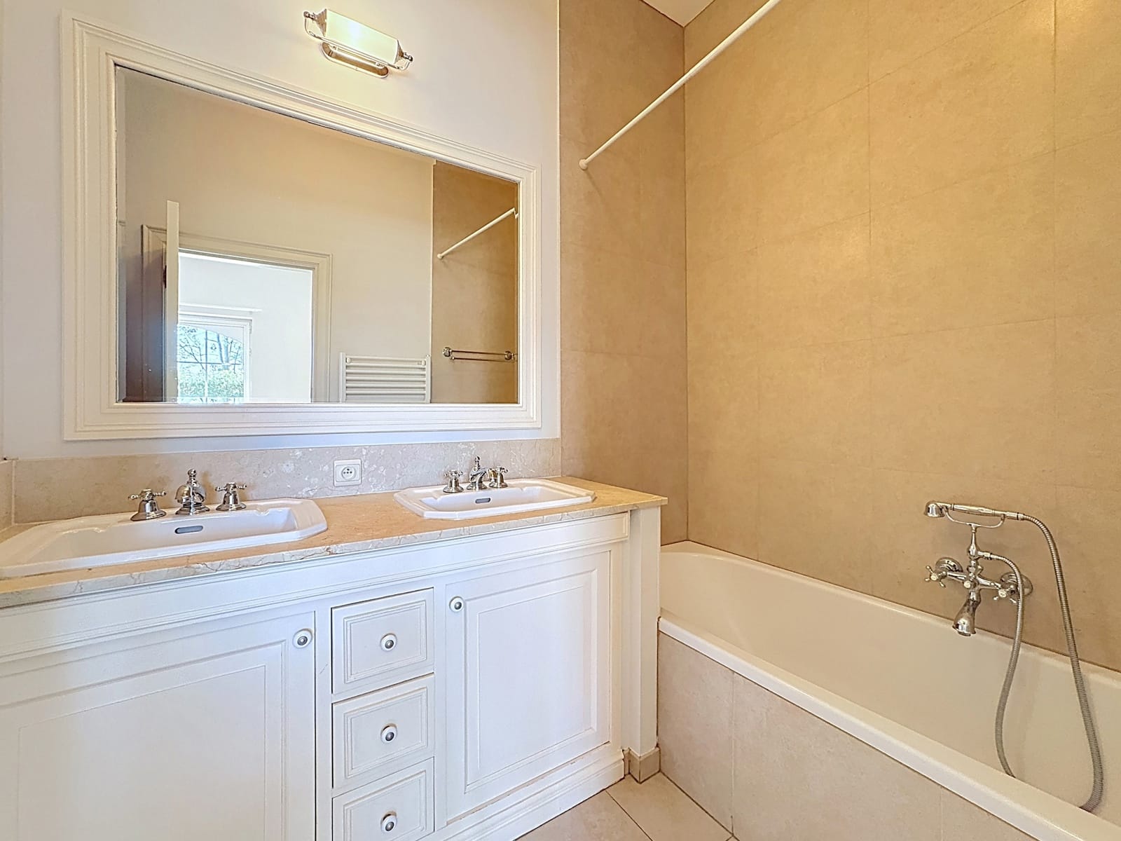 Salle de Bains avec Double Vasque – You Real Estate Agency Salle de bains élégante avec double vasque et baignoire dans appartement lumineux.