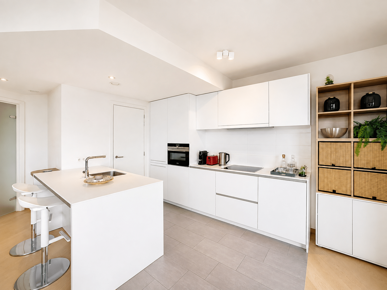Cuisine Moderne Blanche avec Îlot – You Real Estate Agency Cuisine moderne blanche avec îlot central et électroménagers intégrés dans une maison contemporaine.