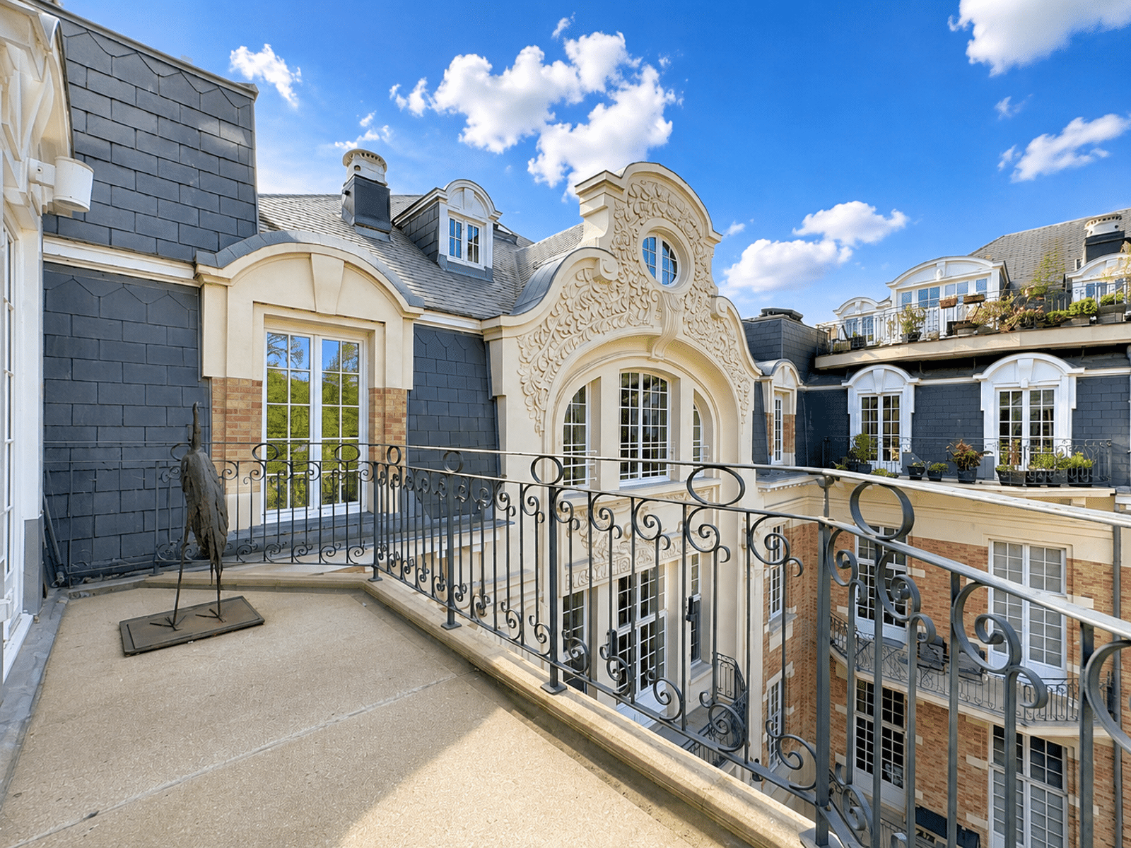 Balcony Overlooking a Haussmann-Style Courtyard – You Real Estate Agency Apartment terrace with a view of the inner courtyard and the Haussmann-style facade.