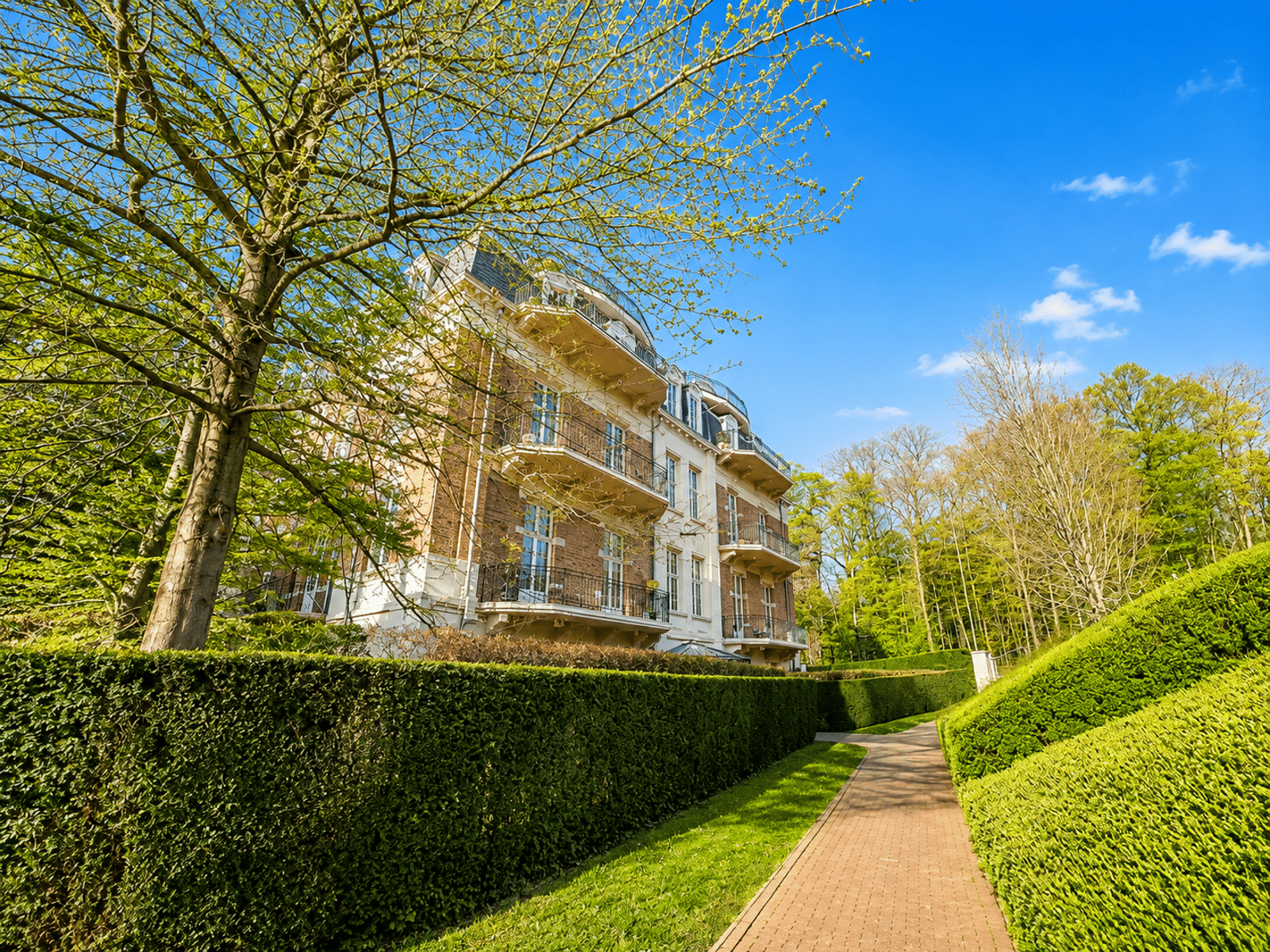 Residence with Landscaped Garden – You Real Estate Agency Luxury apartment building with balconies and a landscaped garden.