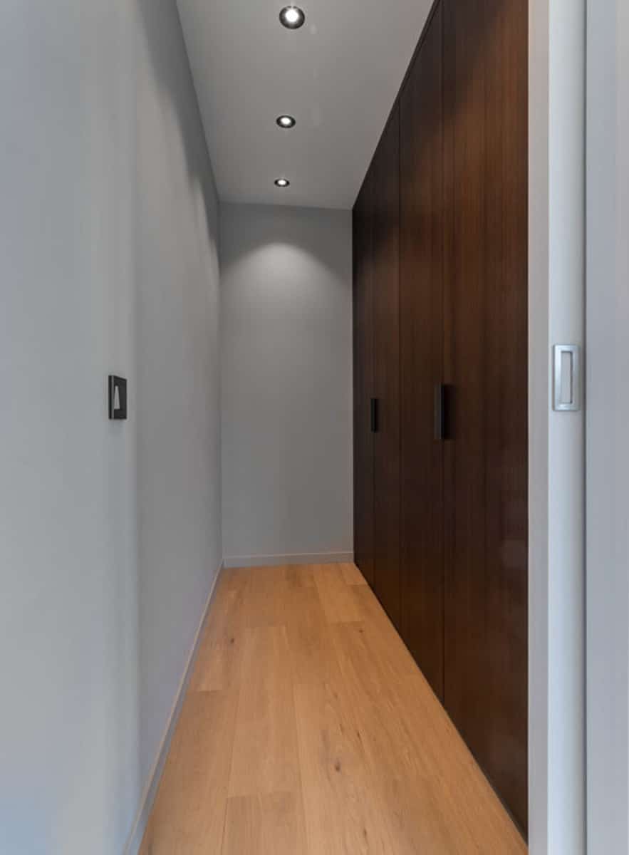 Couloir Moderne avec Placards Intégrés – You Real Estate Agency Couloir moderne d’appartement avec placards intégrés en bois et parquet clair.
