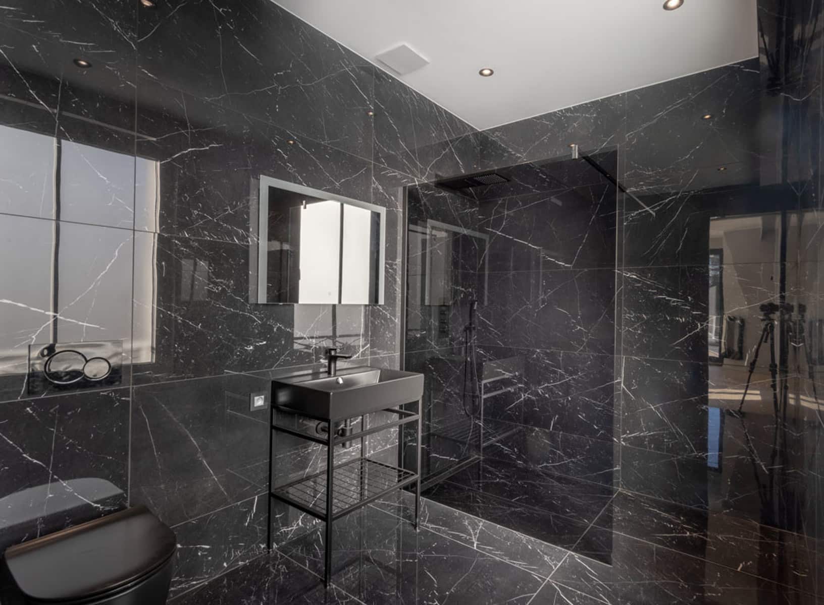 Salle de Bain en Marbre Noir – You Real Estate Agency Salle de bain moderne en marbre noir dans un appartement haut de gamme.