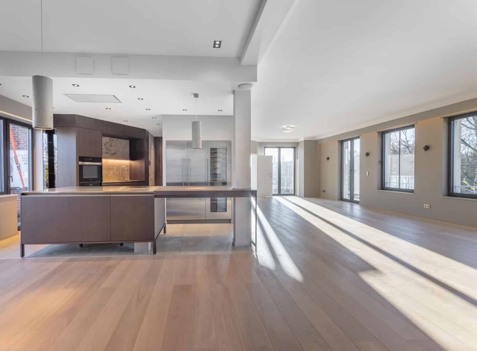 whise photo 10 Modern open-plan kitchen with a dark wood island, stainless appliances, and large windows filling the space with natural light.