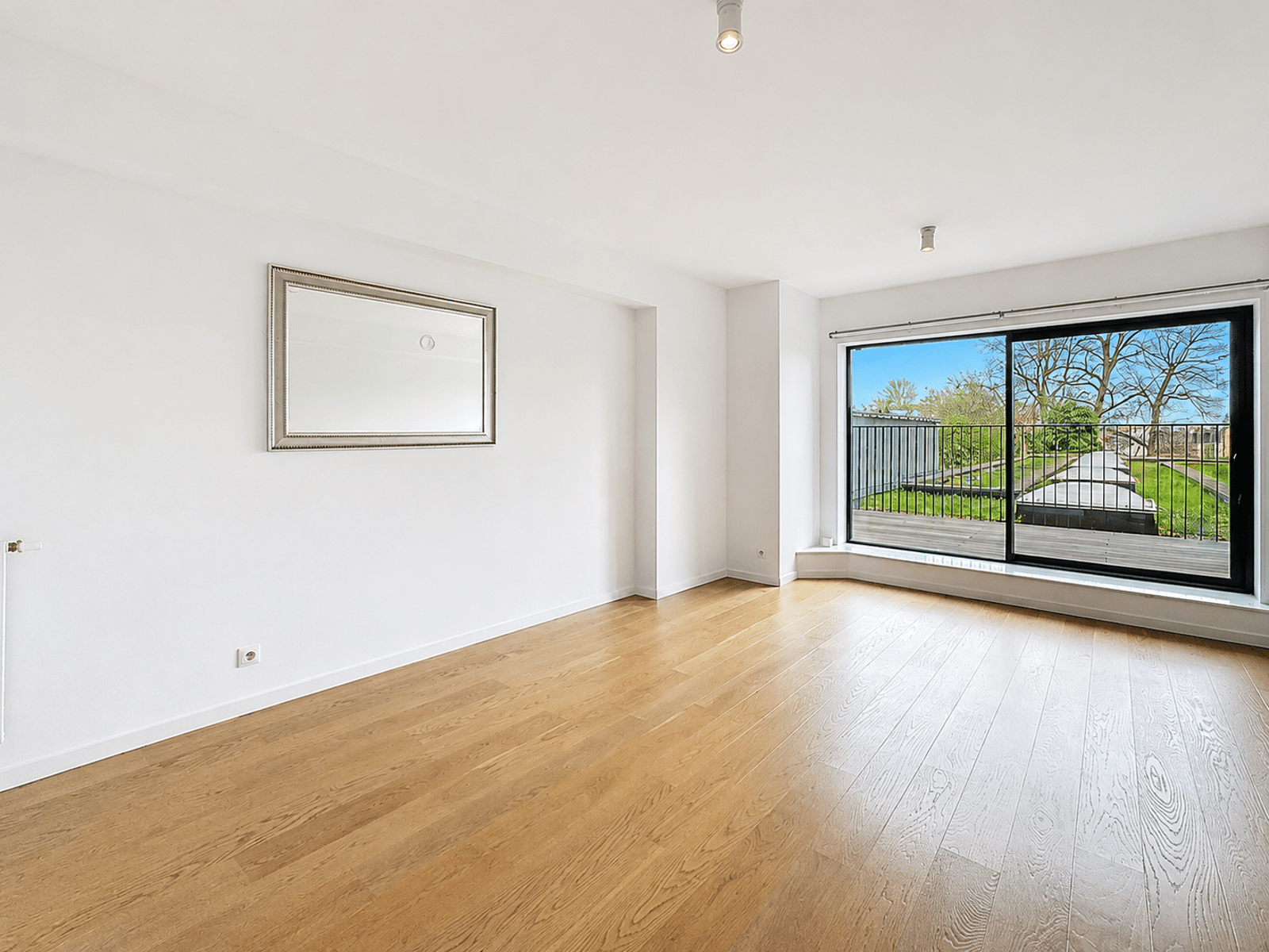 Salon Lumineux avec Terrasse et Jardin – You Real Estate Agency Salon lumineux avec parquet, baie vitrée sur terrasse et jardin.