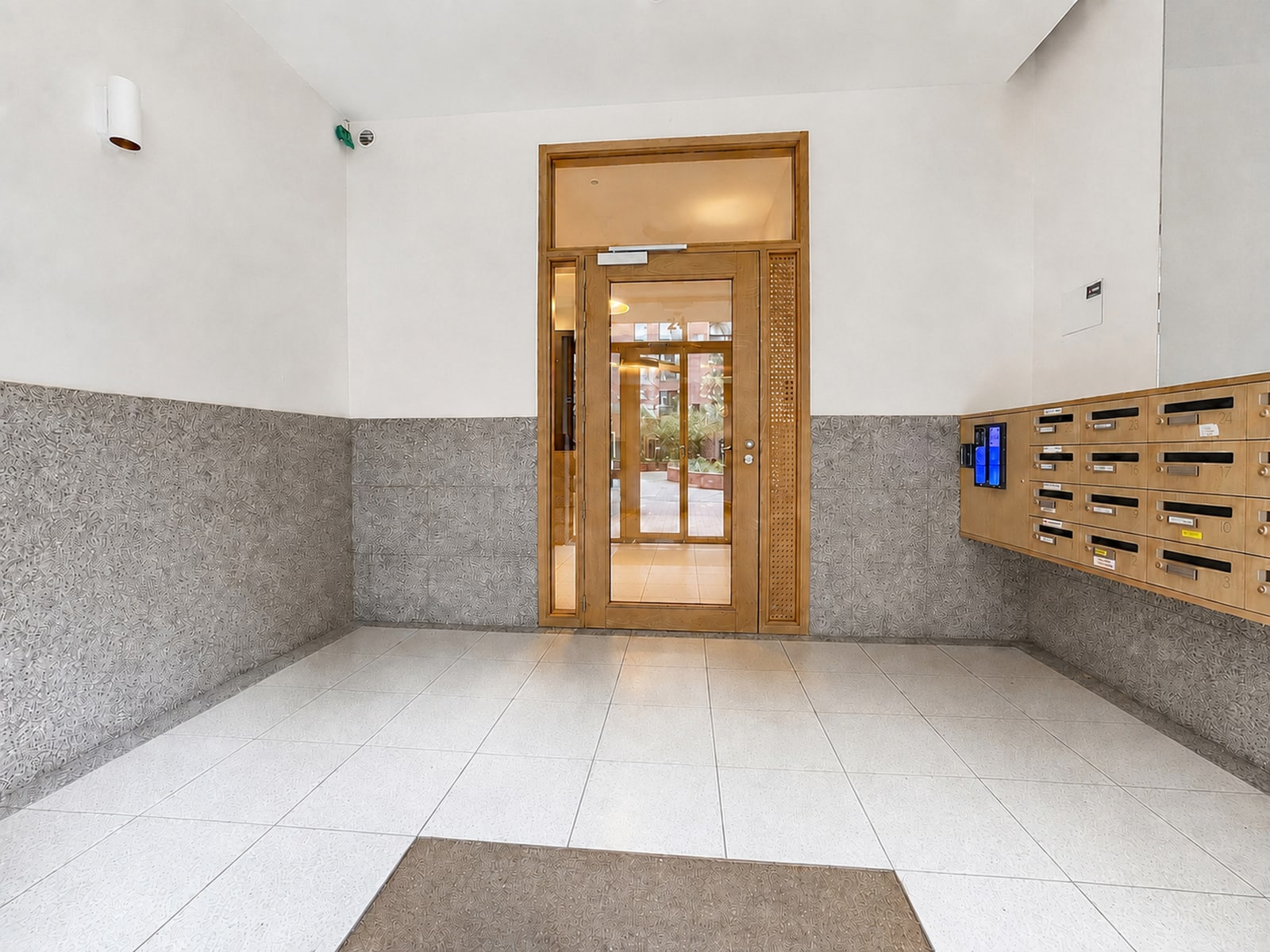 Hall d’Immeuble Moderne – You Real Estate Agency Hall d’entrée moderne d’immeuble d’appartements avec boîtes aux lettres et porte vitrée.