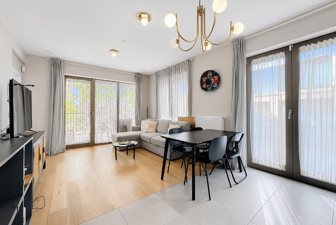 Salon et salle à manger lumineux d’appartement moderne avec grandes fenêtres.
