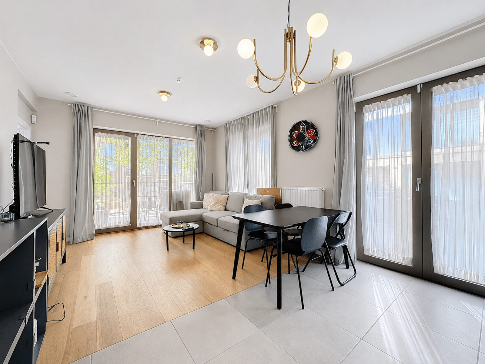 Salon et Salle à Manger Lumineux – You Real Estate Agency Salon et salle à manger lumineux d’appartement moderne avec grandes fenêtres.