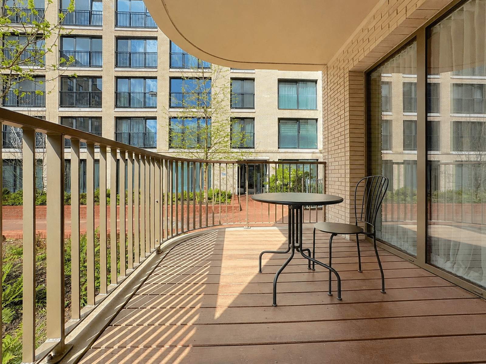 Balcon-Terrasse Moderne Sur Cour – You Real Estate Agency Balcon-terrasse d’appartement moderne avec parquet bois et vue sur cour intérieure.