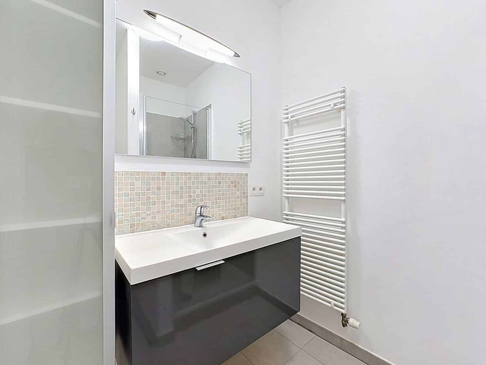 Salle de Bain Moderne - You Real Estate Agency Modern bathroom with a vanity unit and shower in a renovated apartment.