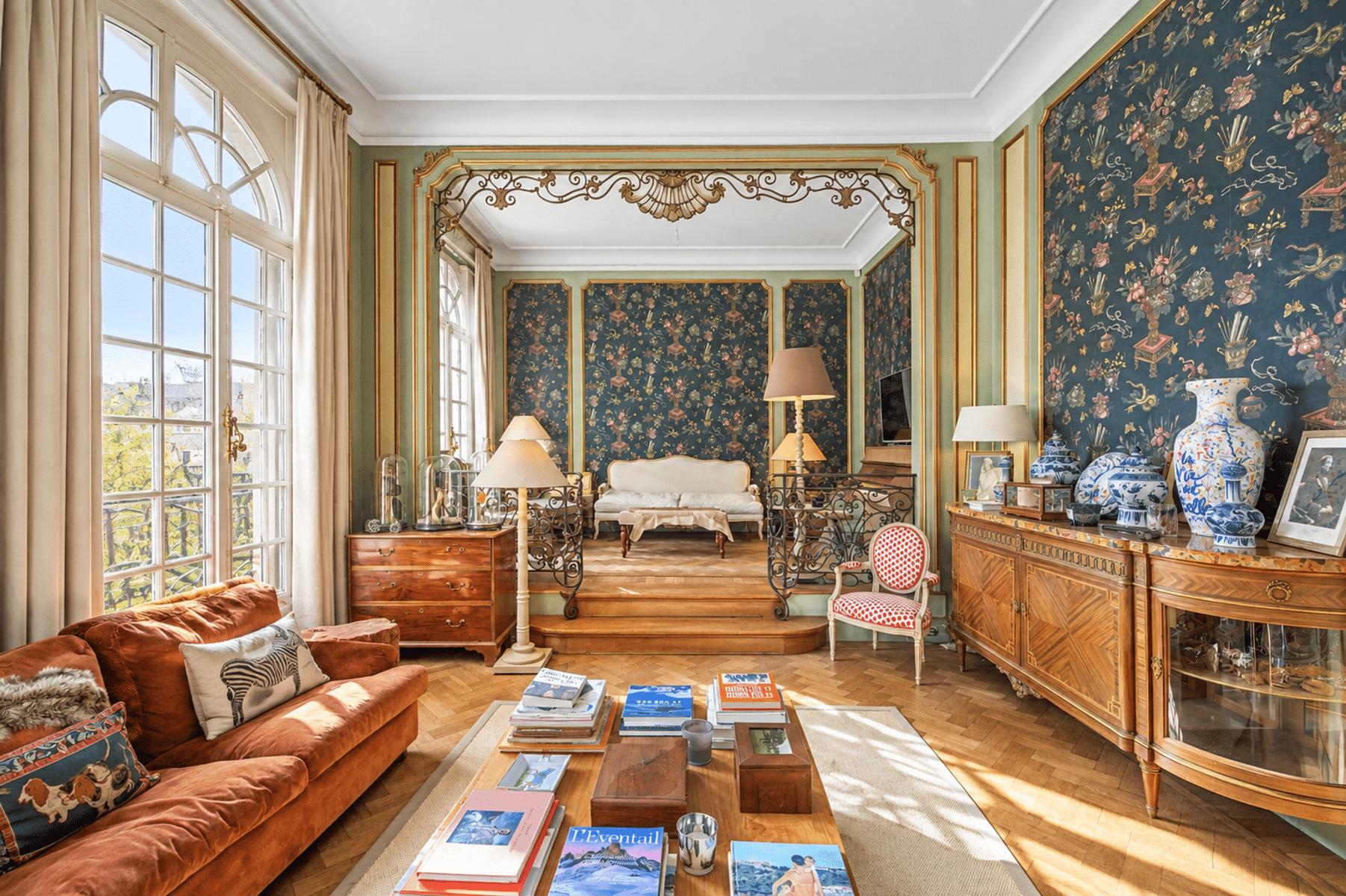 Lichte, klassieke woonkamer met parketvloer – You Real Estate Agency Een lichte, klassieke woonkamer met visgraatparket, vergulde sierlijsten en antieke meubels.