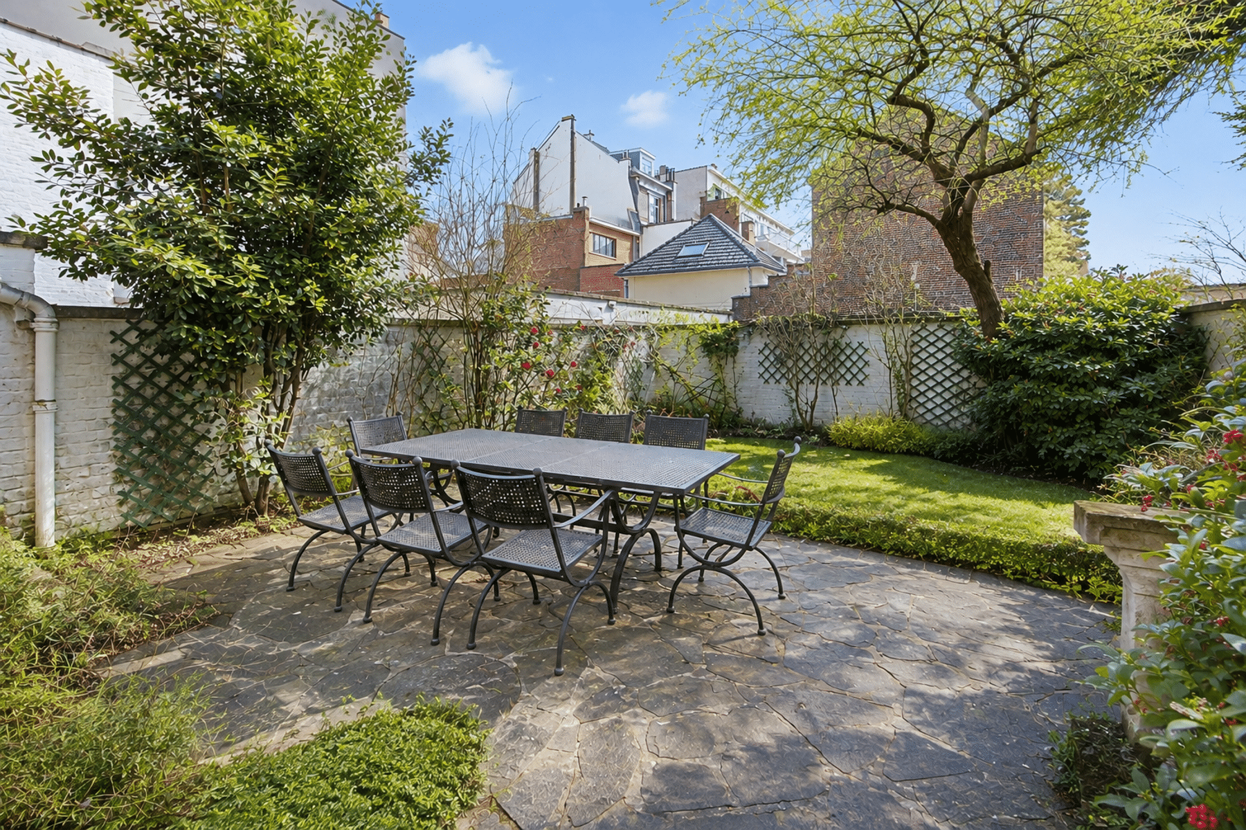 Stenen terras en omheinde tuin – You Real Estate Agency Stenen terras met tuinmeubilair in een huis met omheinde tuin.