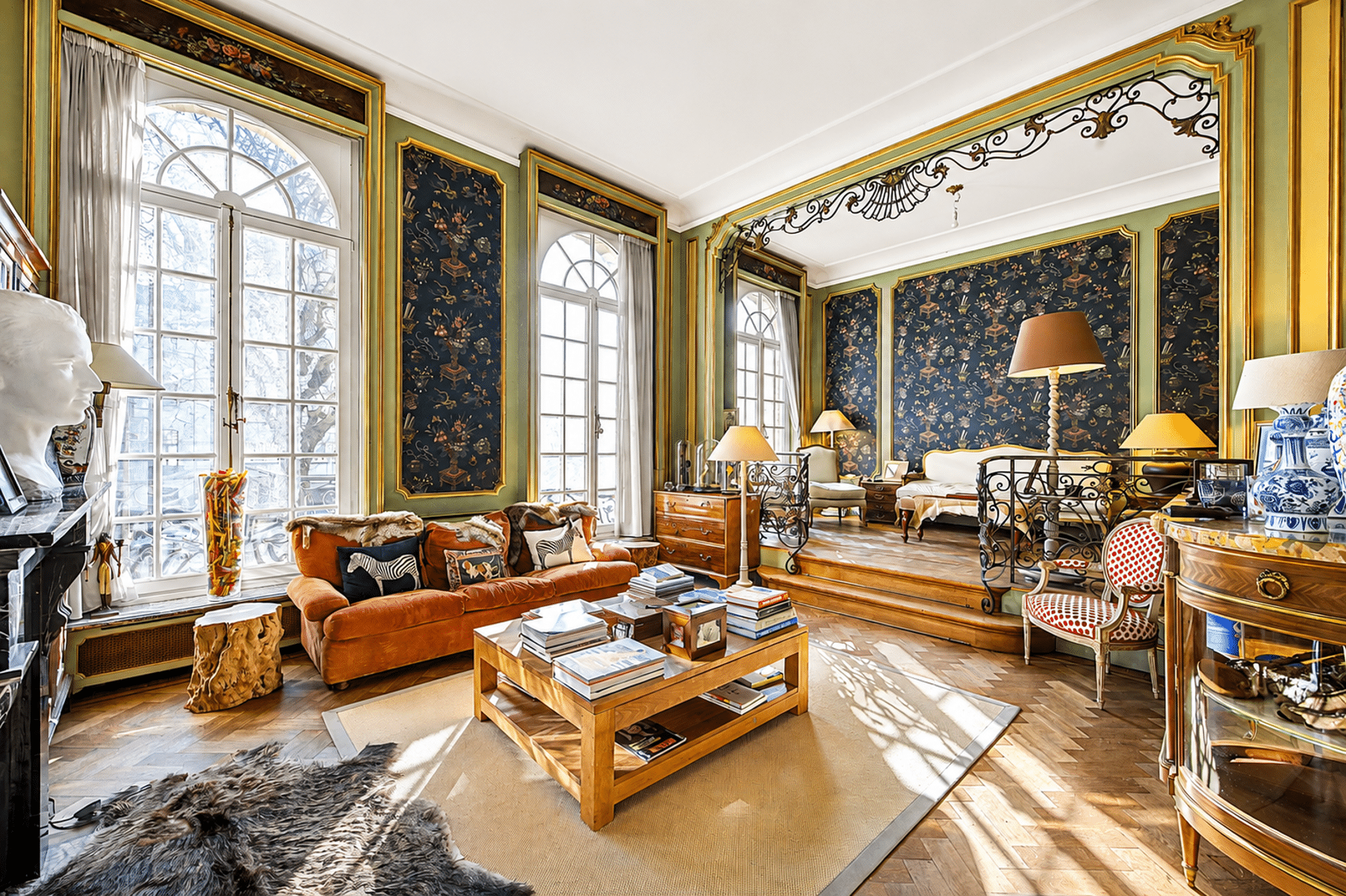 Lichte woning in Haussmann-stijl – You Real Estate Agency Lichte woonkamer in Haussmann-stijl met vergulde sierlijsten, visgraatparket en grote ramen.