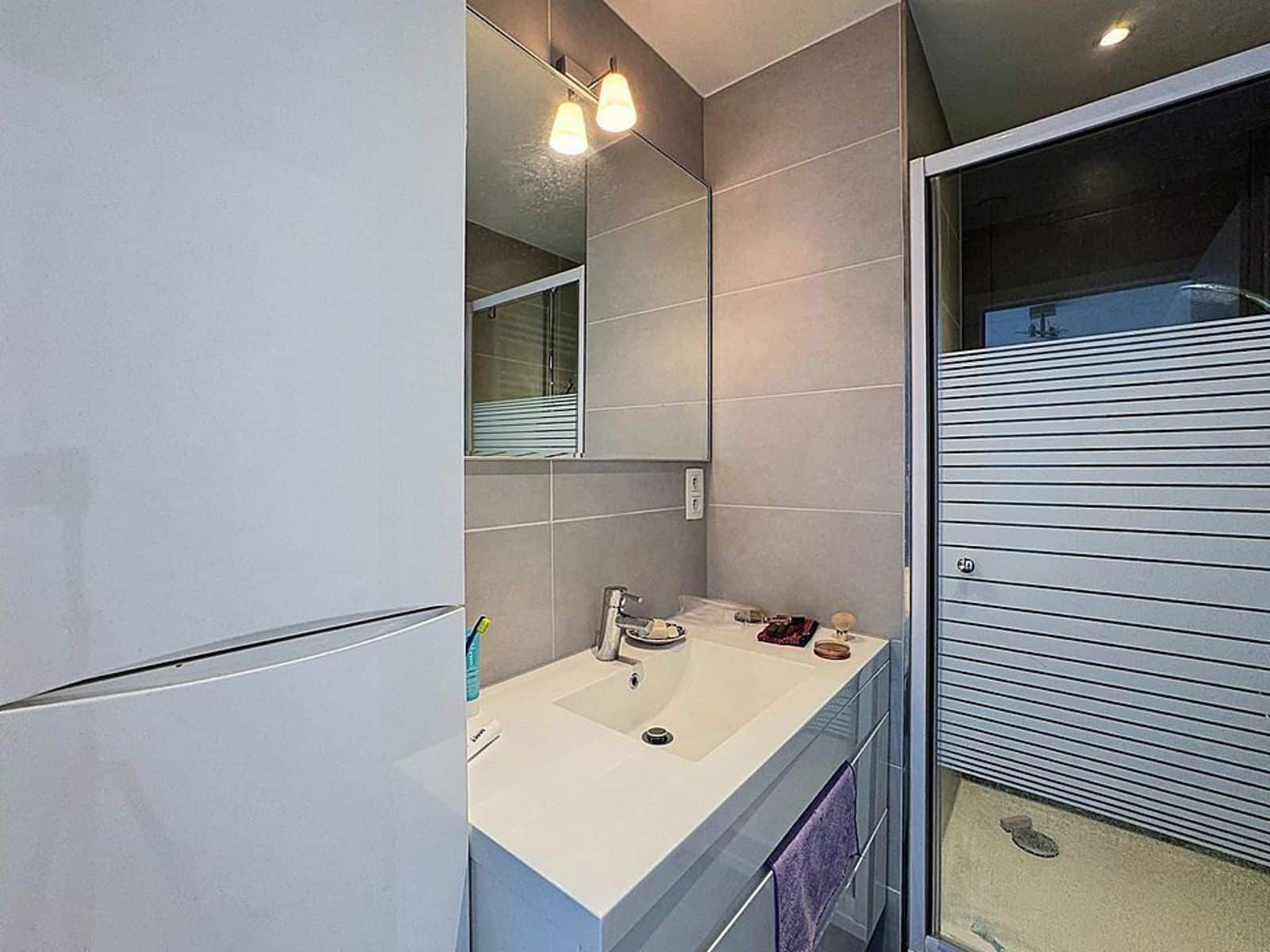 Salle de Bains Moderne avec Douche – You Real Estate Agency Salle de bains moderne avec douche vitrée et meuble vasque dans appartement.