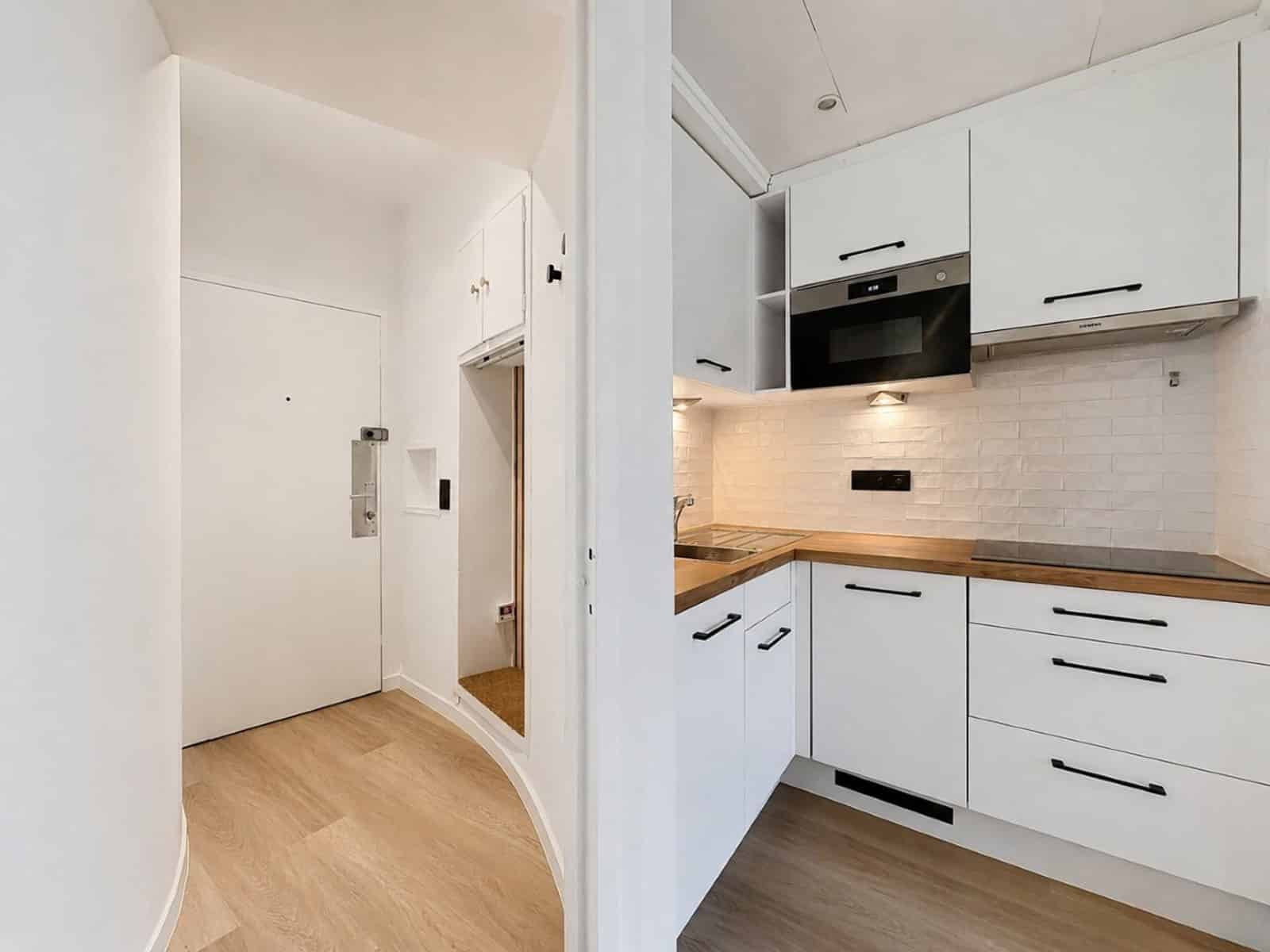 whise photo 5 Modern white L-shaped kitchen with upper and lower cabinets, built-in oven, and wood countertop