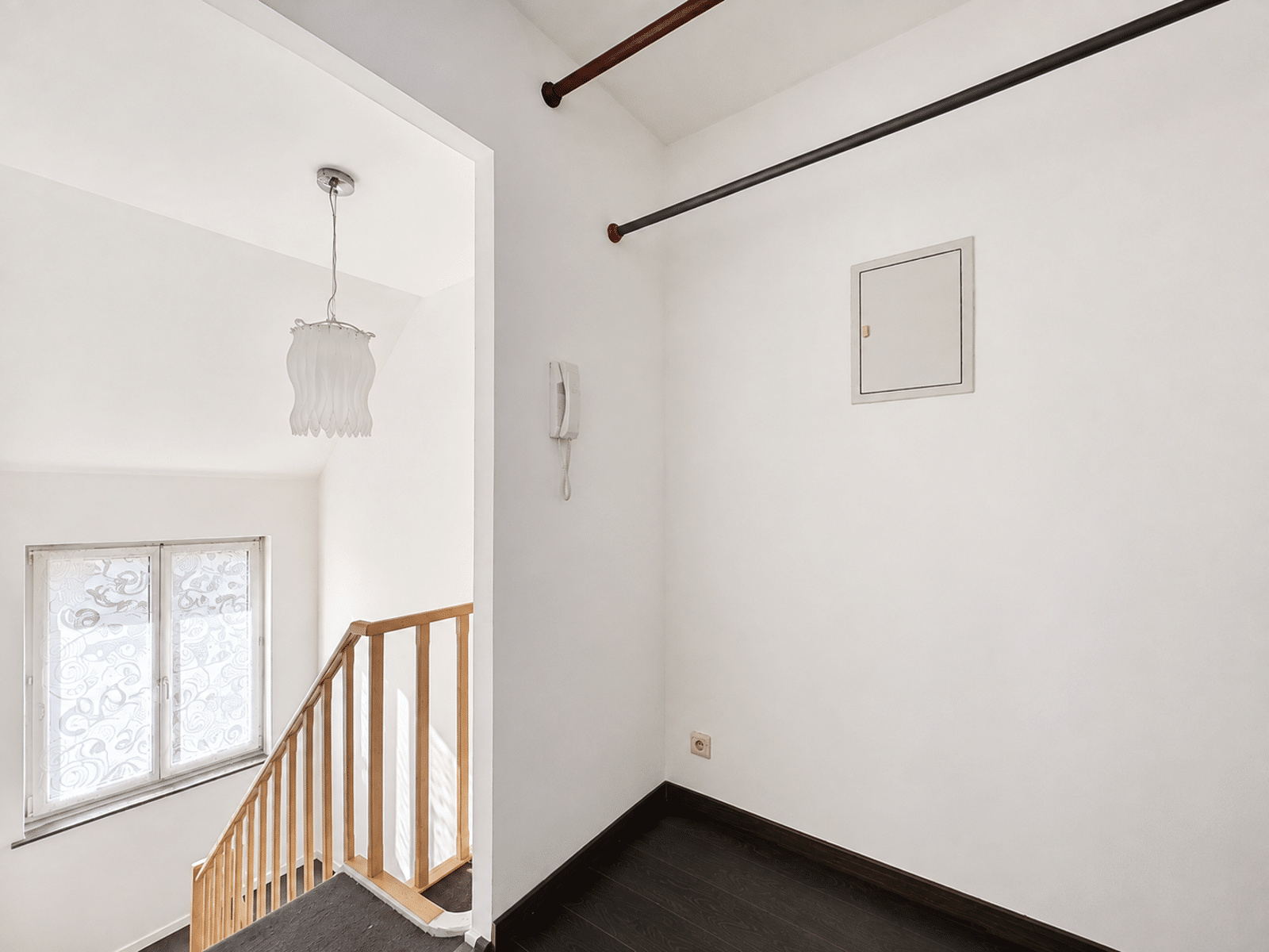 Palier Lumineux avec Escalier – You Real Estate Agency Palier lumineux d’une maison avec escalier, fenêtre décorative et parquet bois.