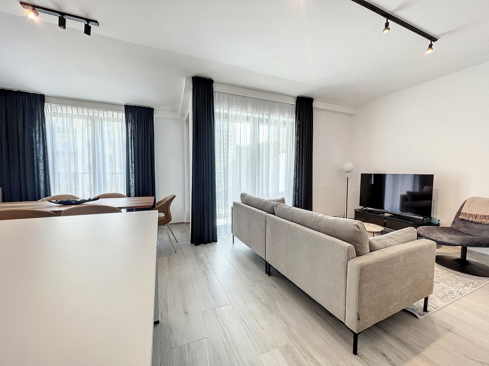 Lichte woon- en eetkamer - You Real Estate Agency Lichte woon- en eetkamer in moderne flat met grote ramen.